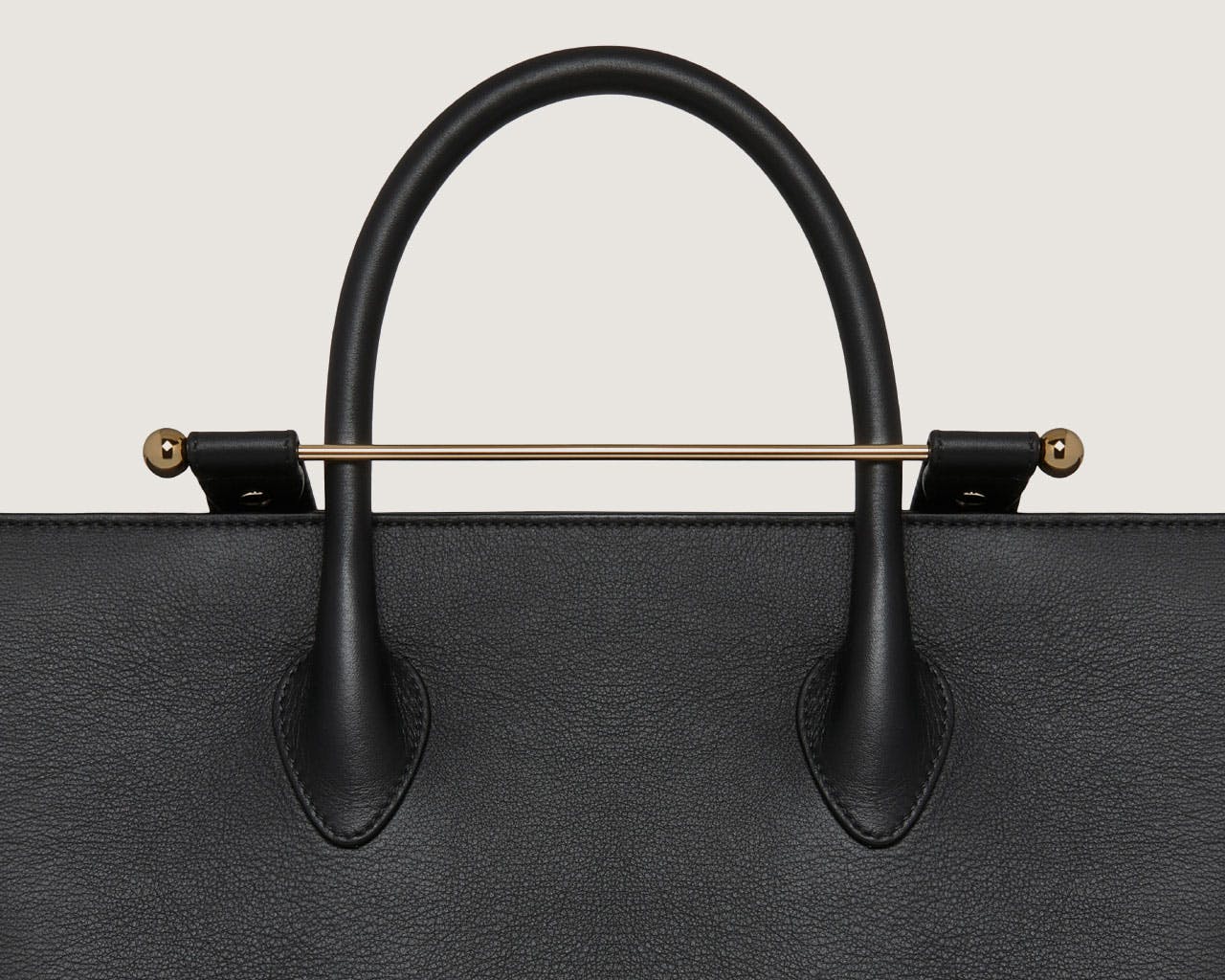 A black handbag with a gold handle