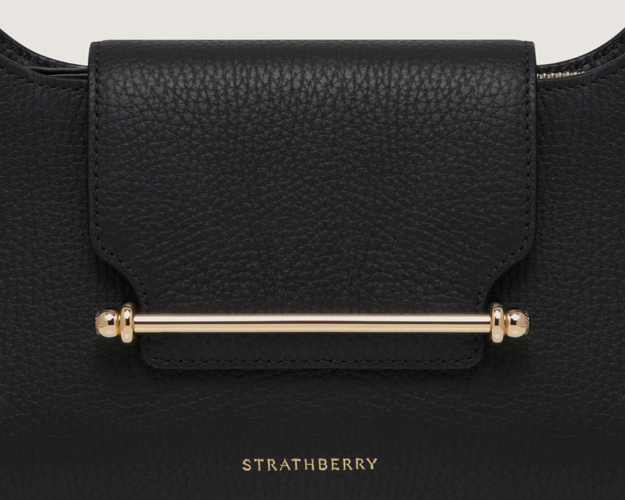 A black handbag with a gold handle