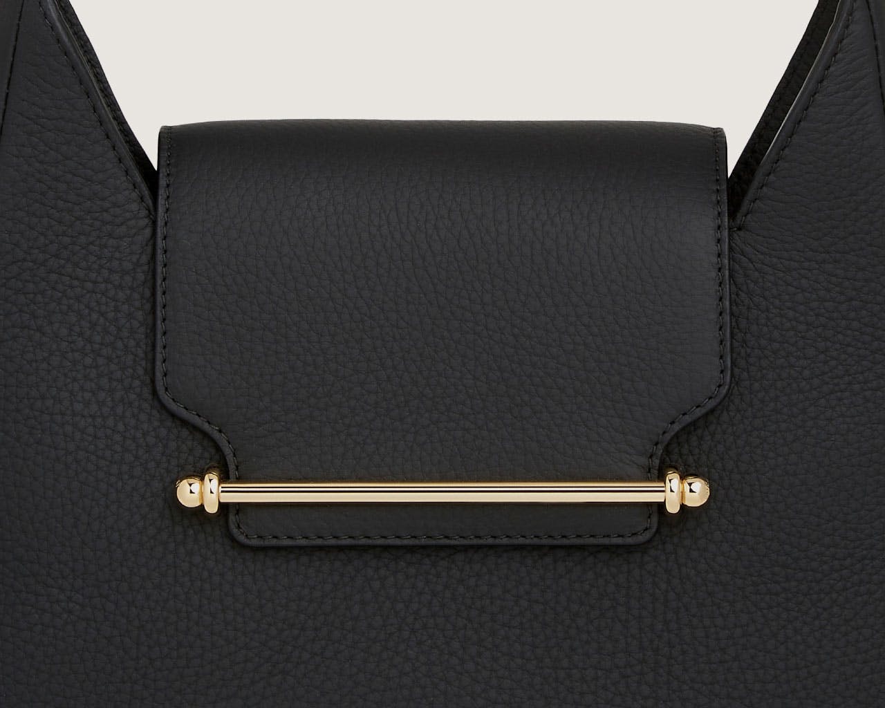 A black handbag with a gold handle