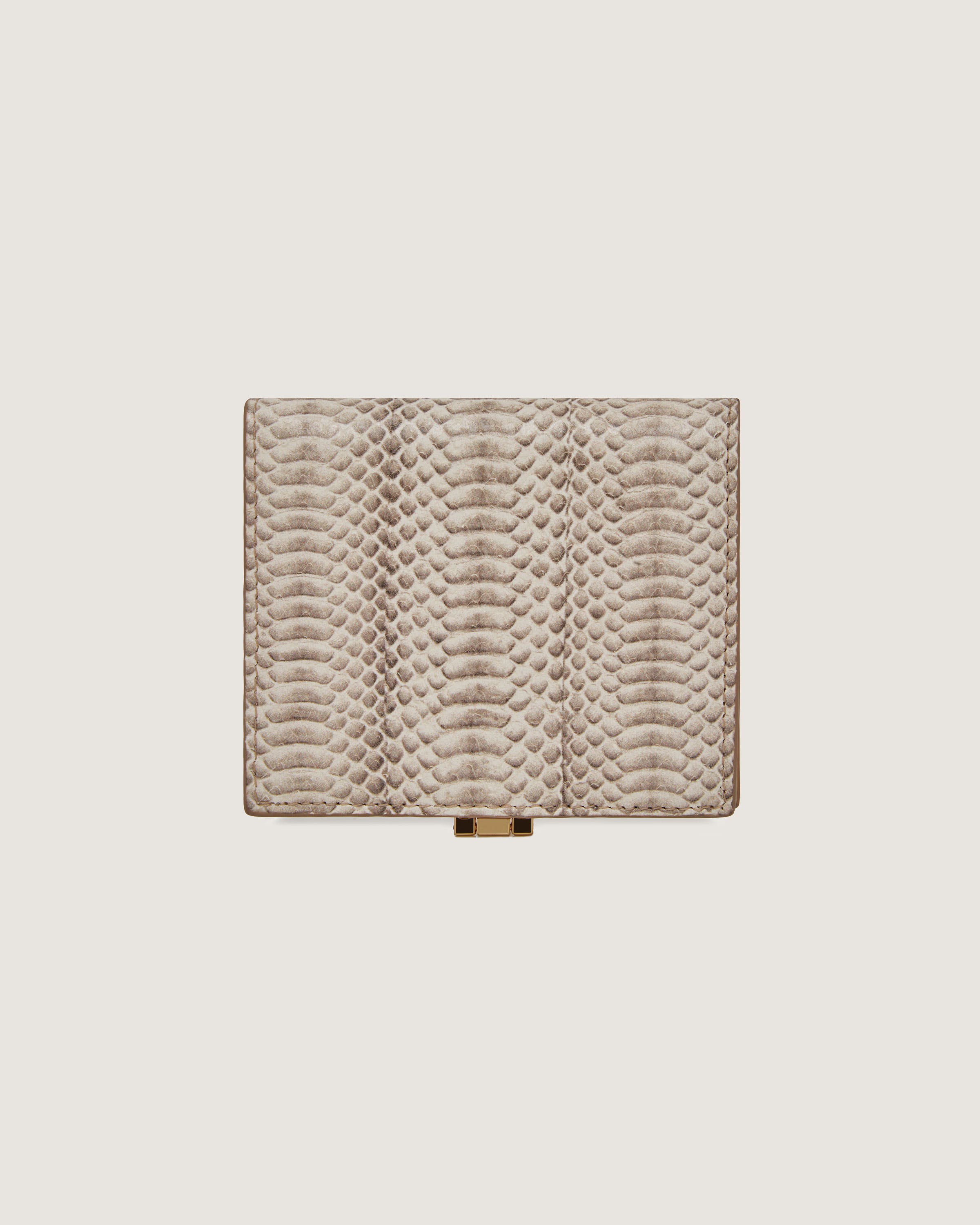 A beige snake skin wallet with a gold clasp