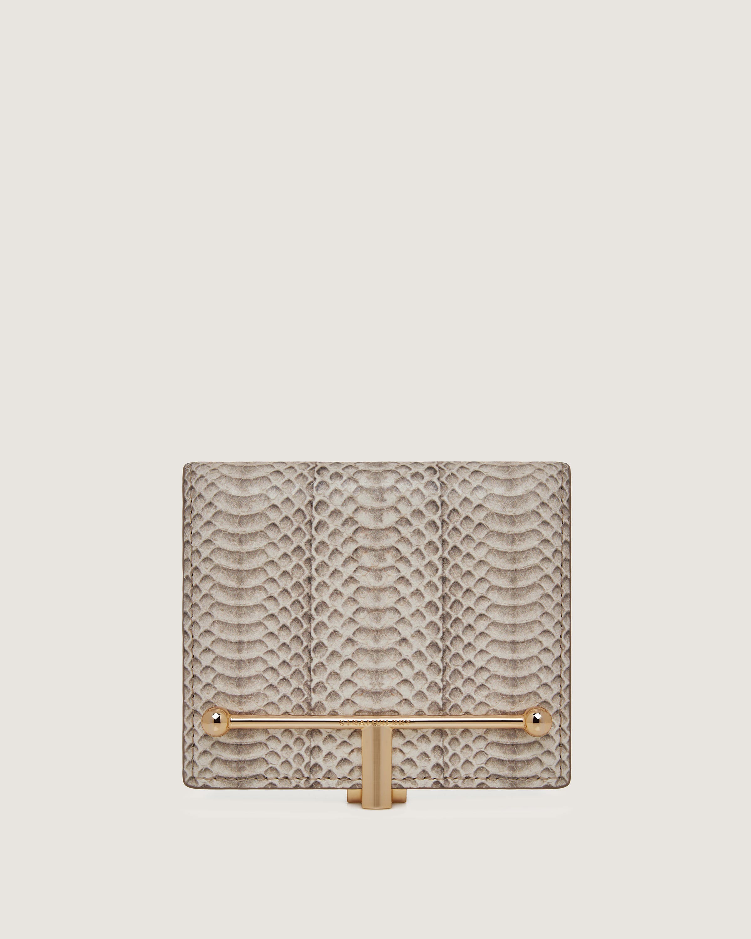 A snake skin purse with a gold handle