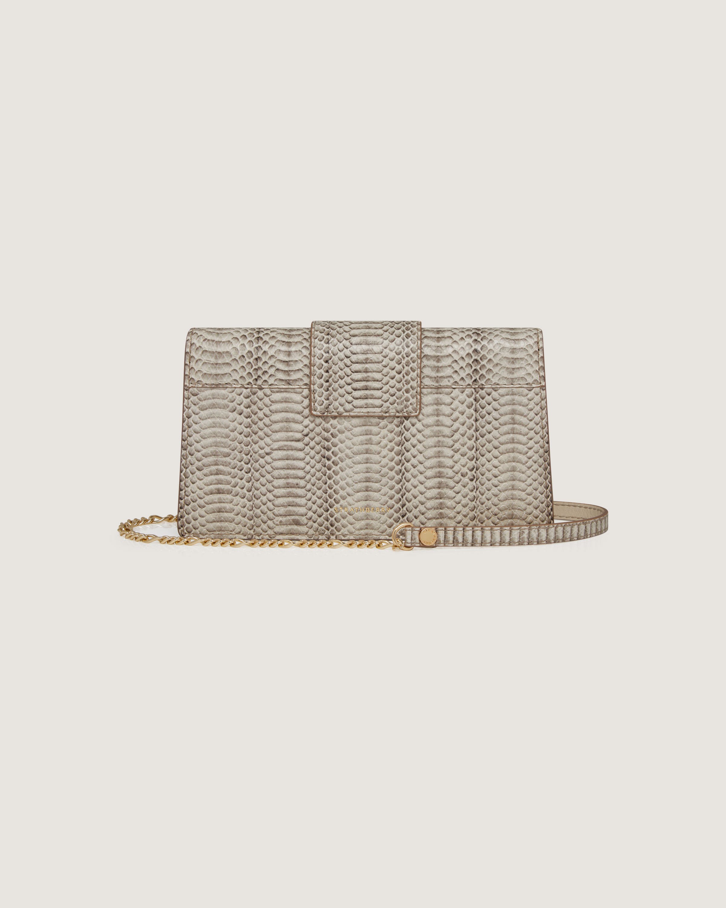 A snake skin purse with a chain strap