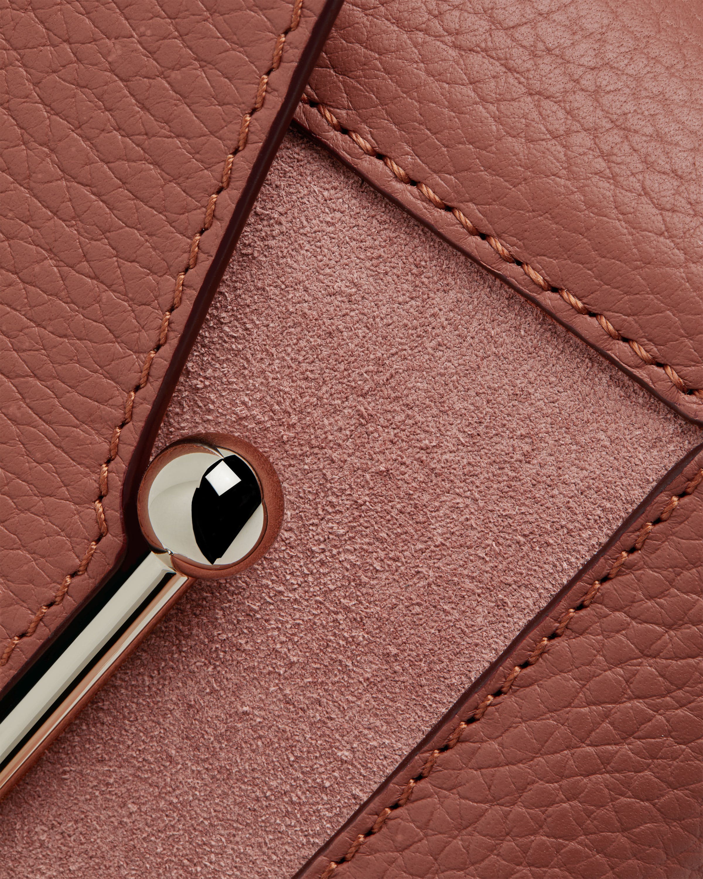 A close up of a pink purse with a metal handle