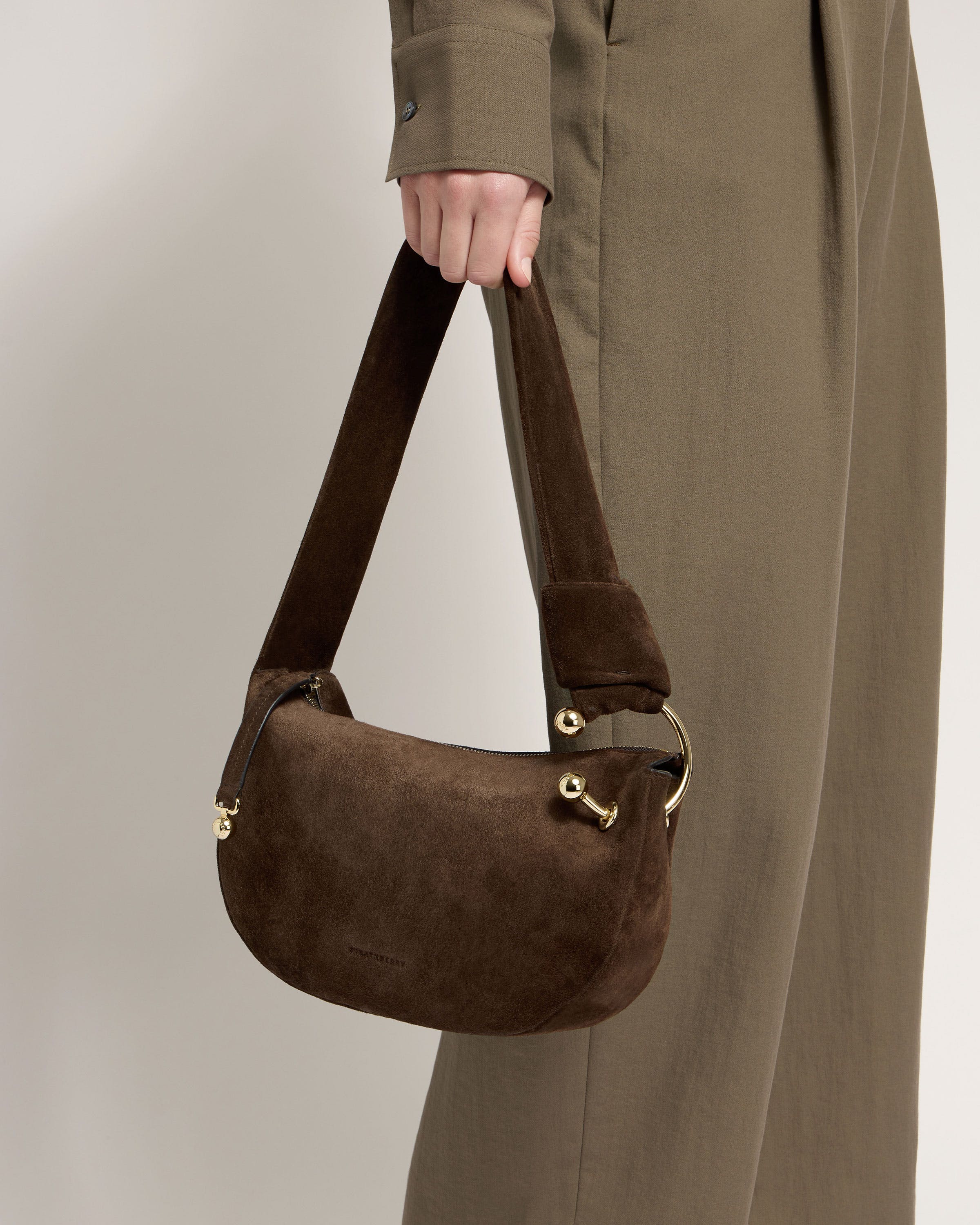 A person is holding a brown bag in their hand