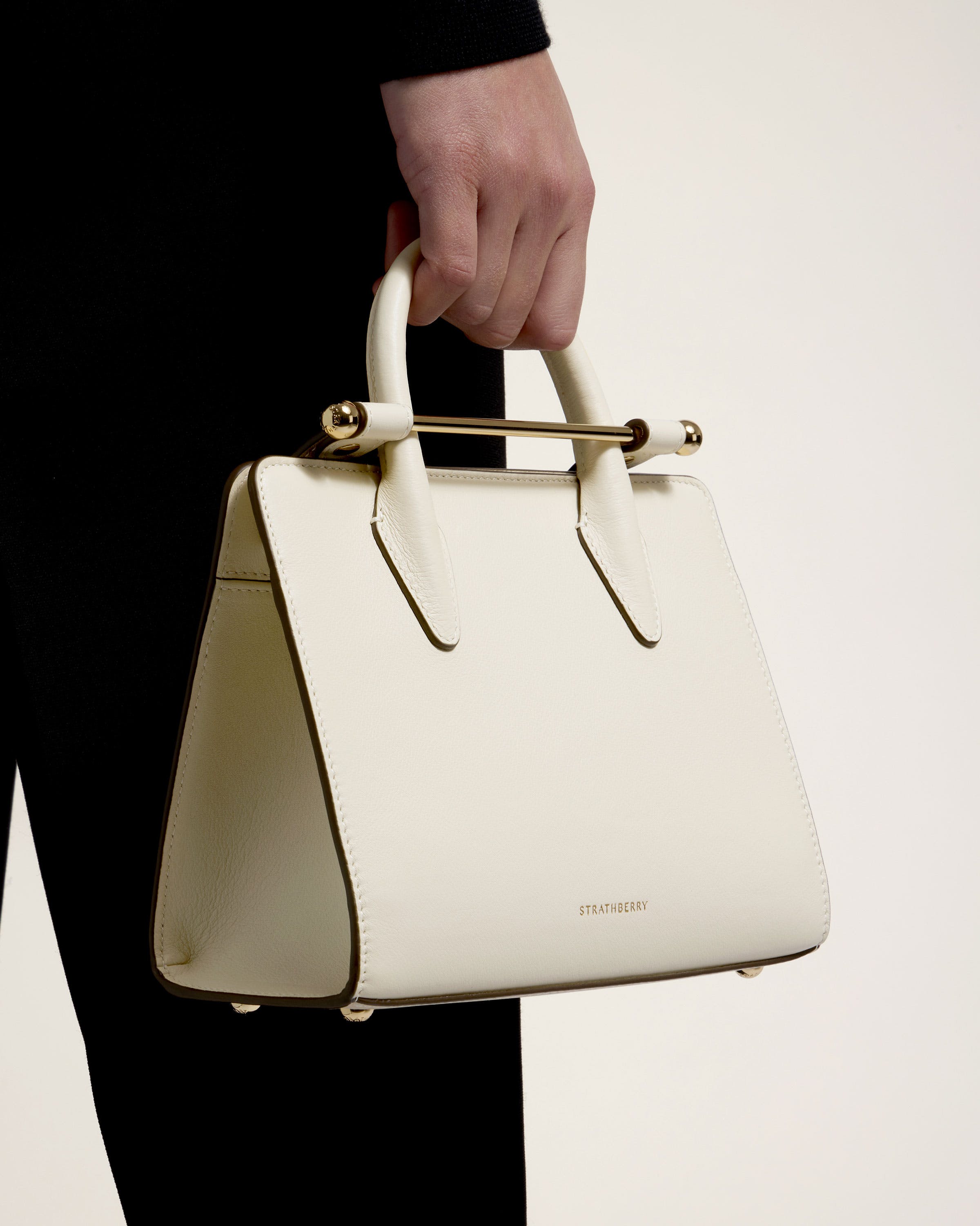 A person holding a white purse in their hand