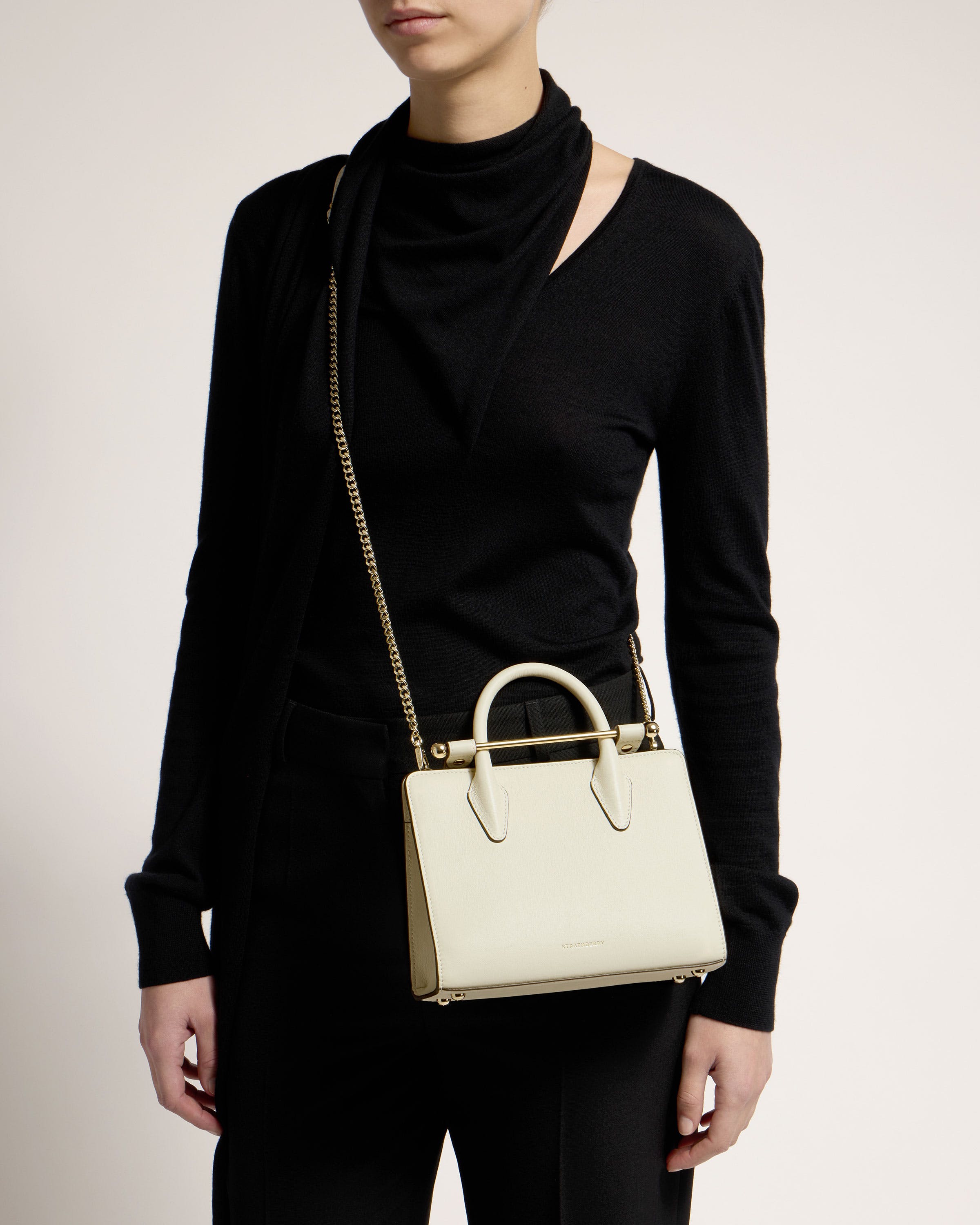 A woman is holding a white purse