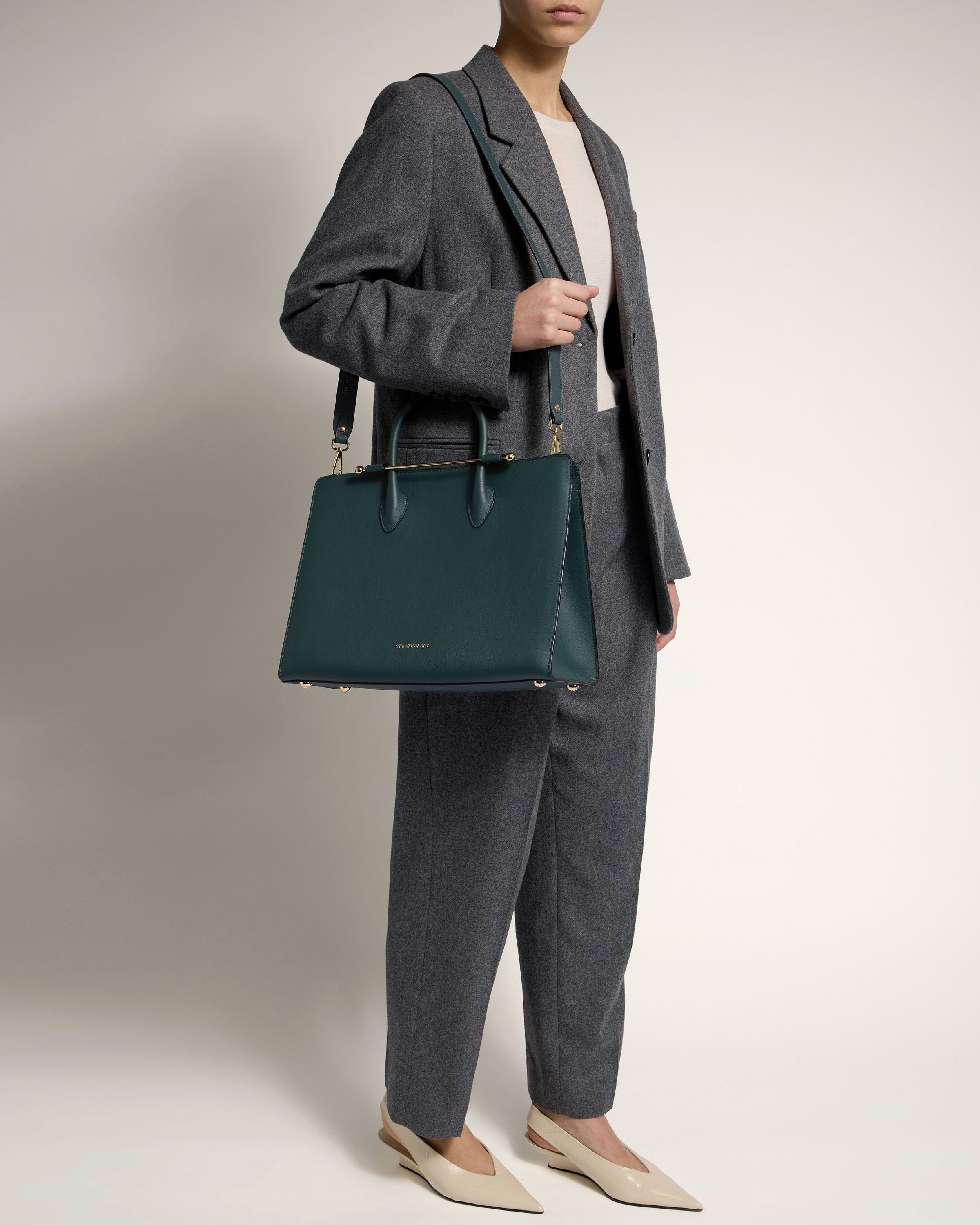 A woman is holding a green handbag