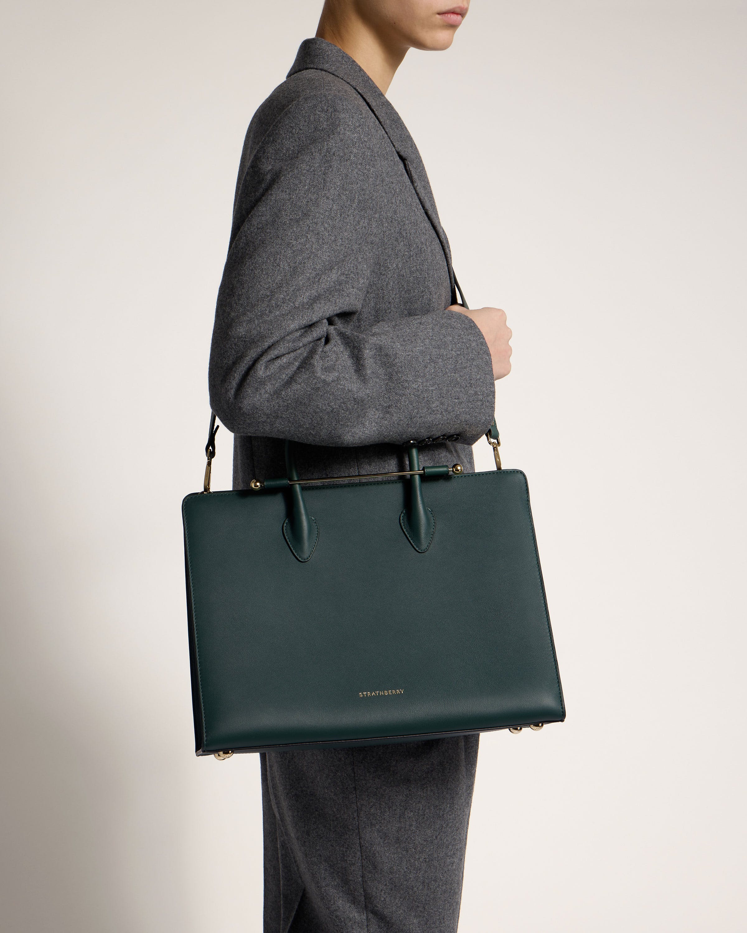 A man in a suit holding a green bag