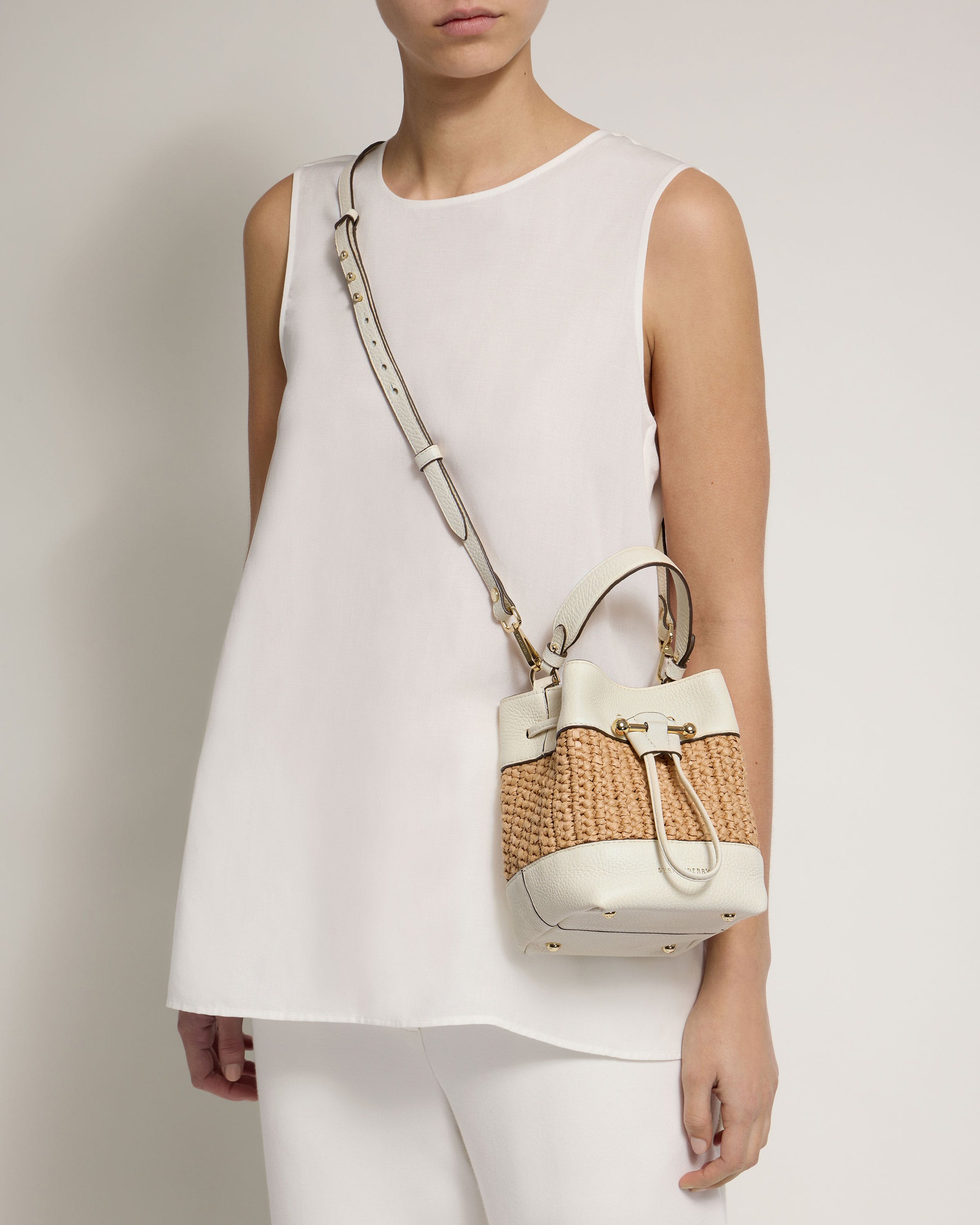 A woman in white holding a white purse