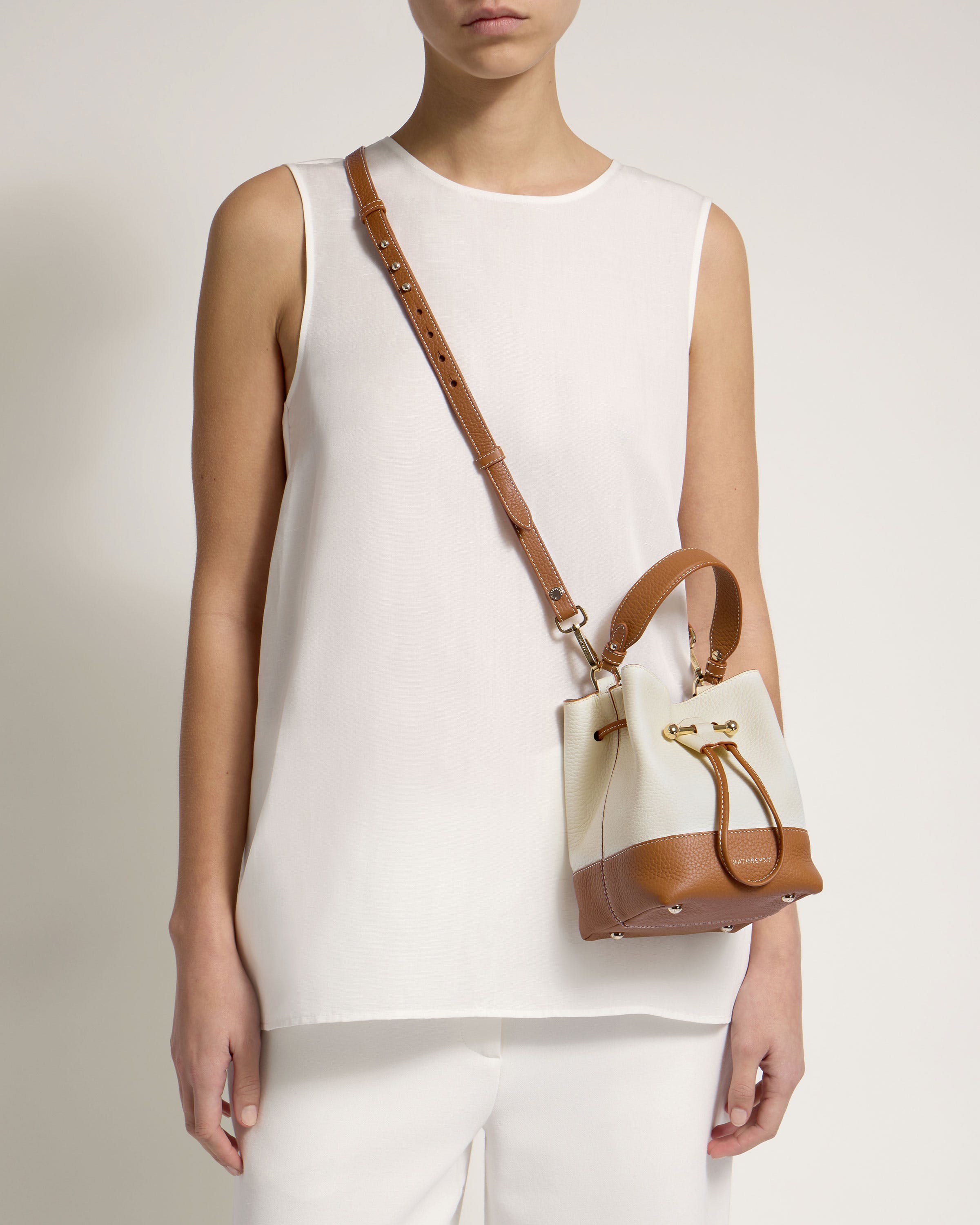 A woman holding a brown and white purse