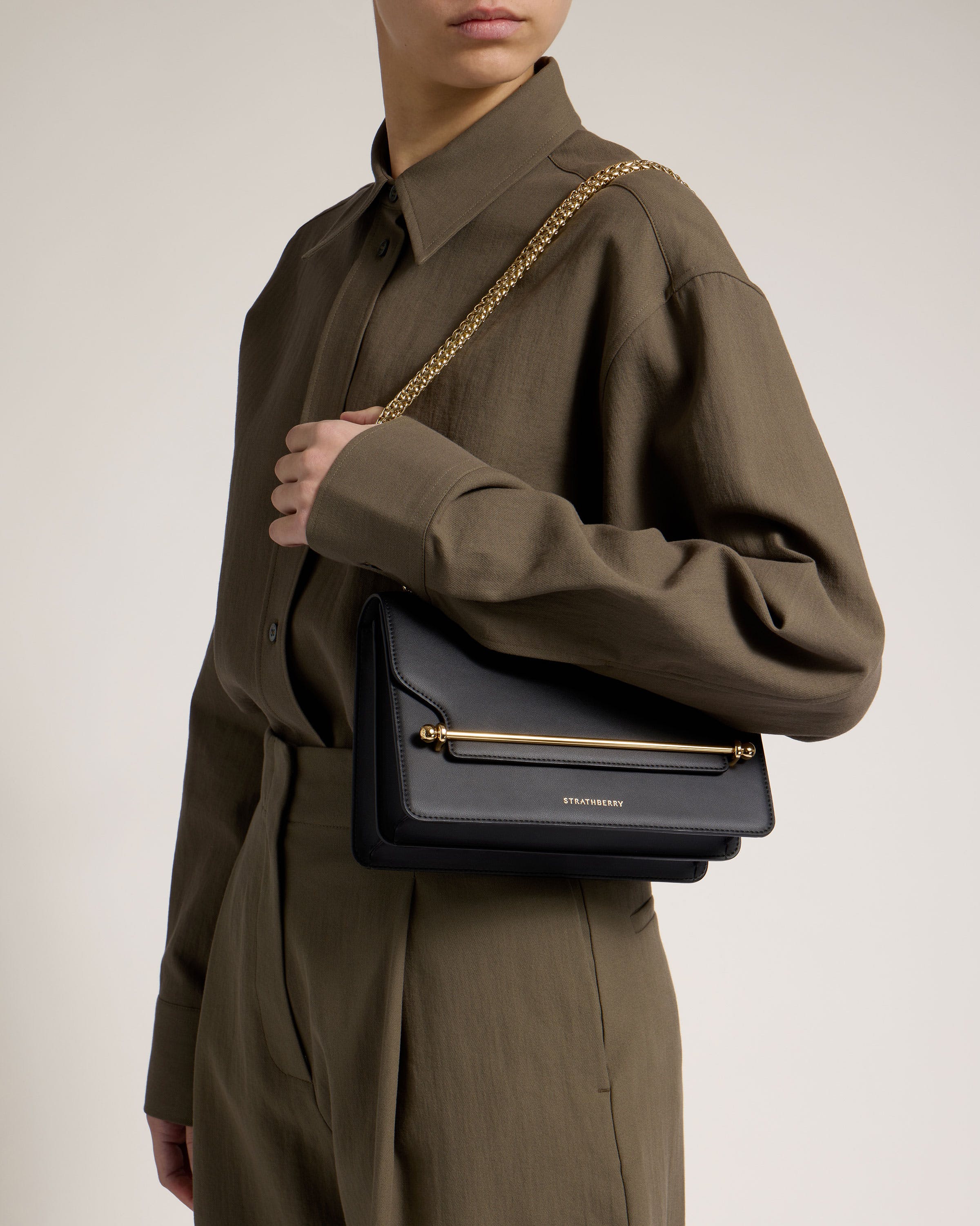 A woman is holding a black handbag