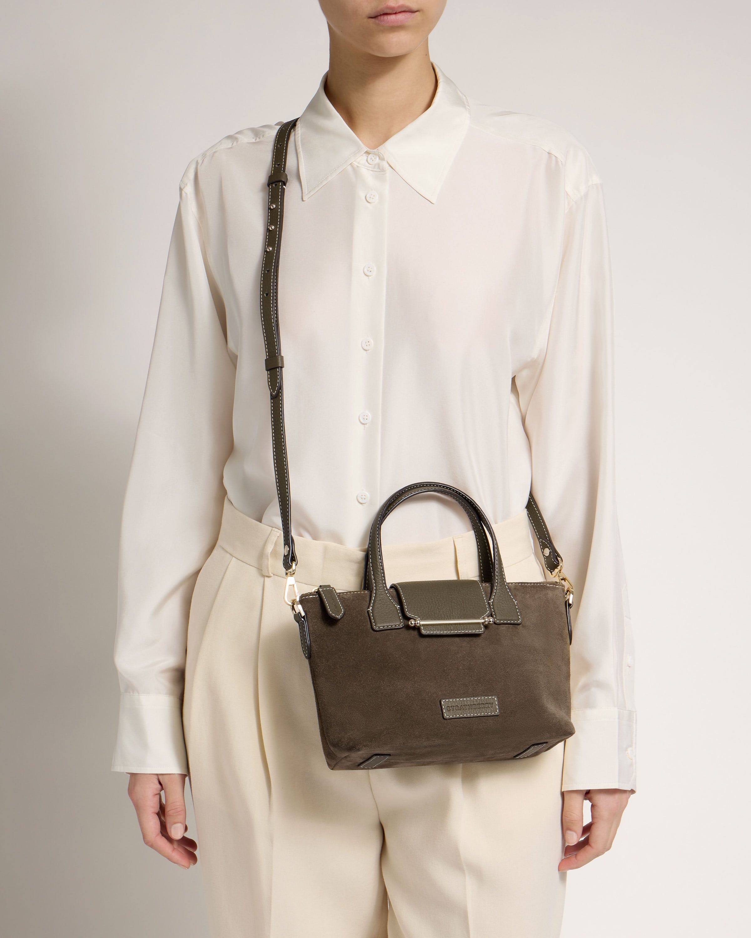 A woman in a white shirt holding a brown bag