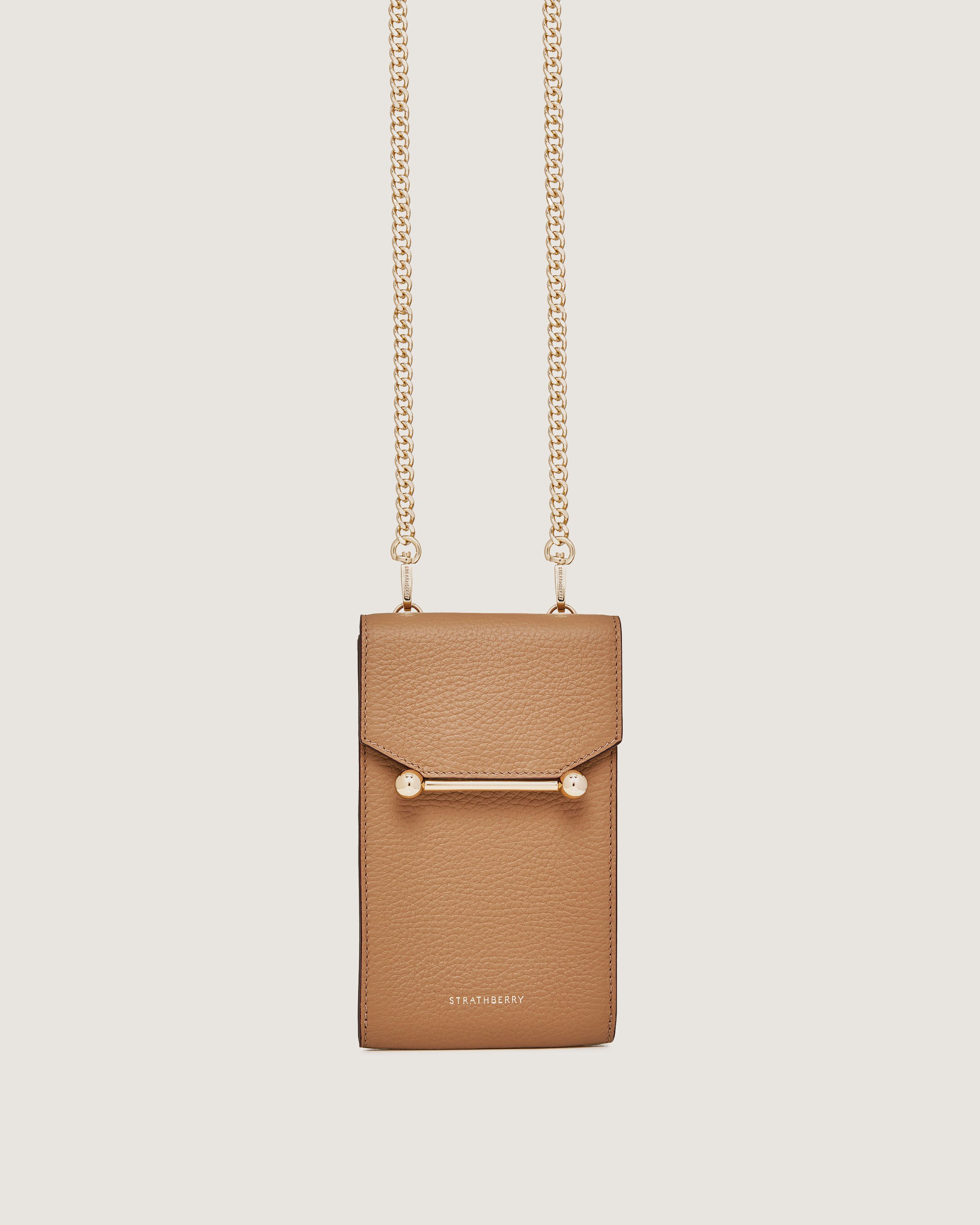 A tan purse with a chain hanging from it