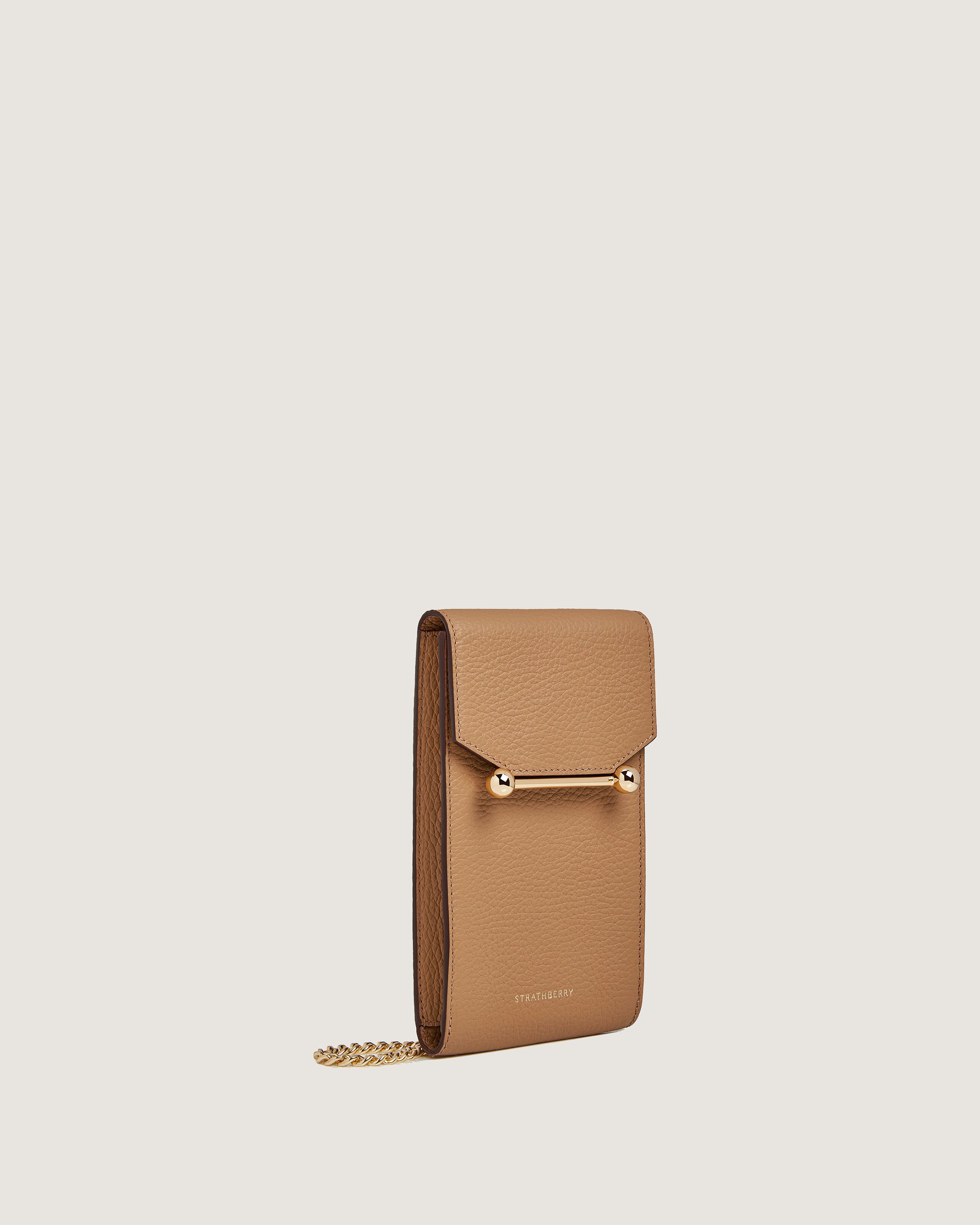 A tan purse with a chain hanging from it