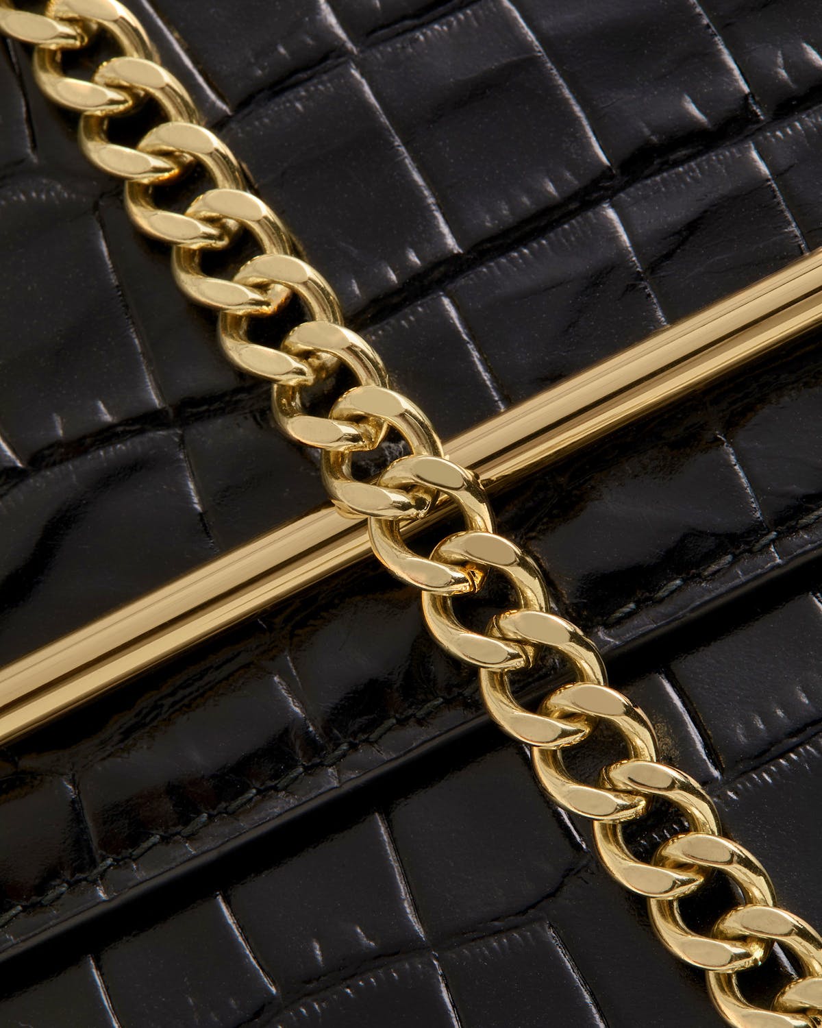 Black croc-effect bag flap with gold curb chain and metal bar