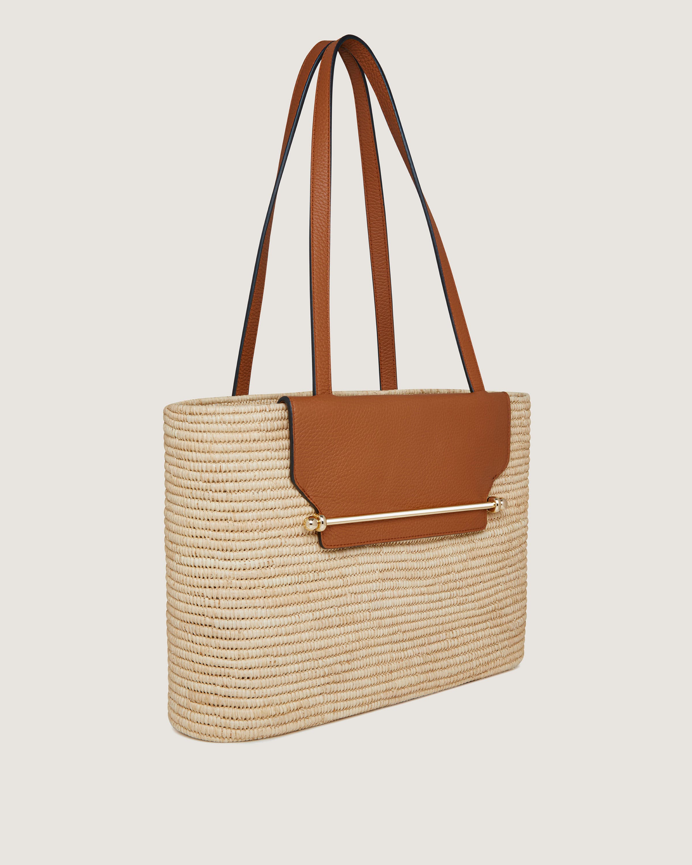 A straw bag with a brown leather handle