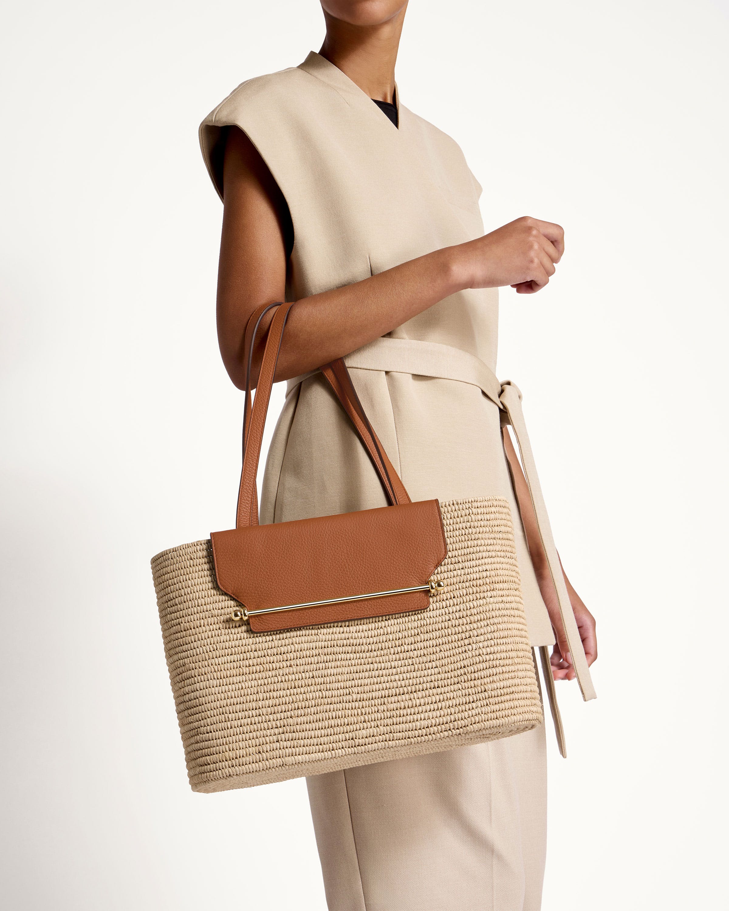 A woman holding a brown and tan purse