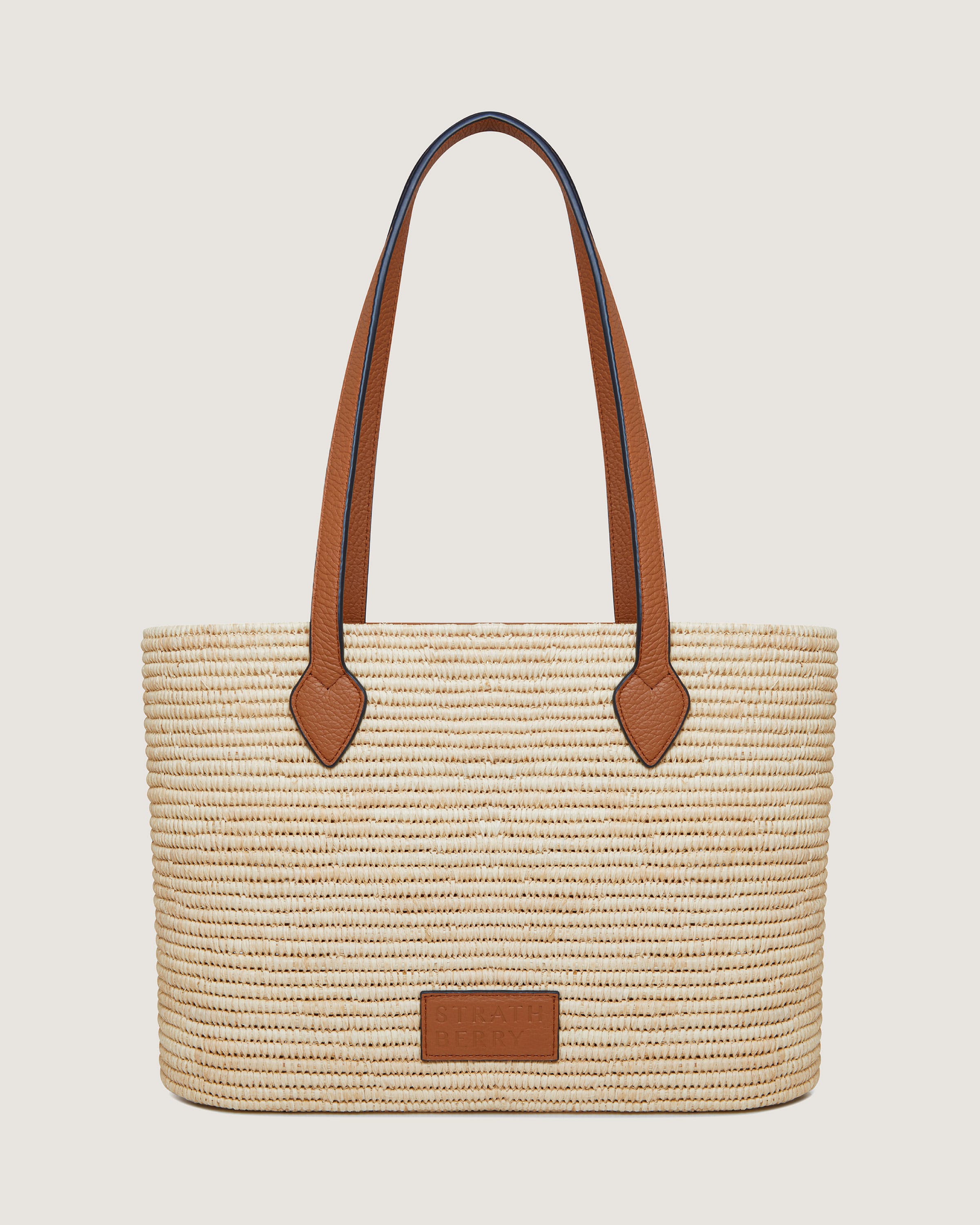 A straw bag with a brown leather handle