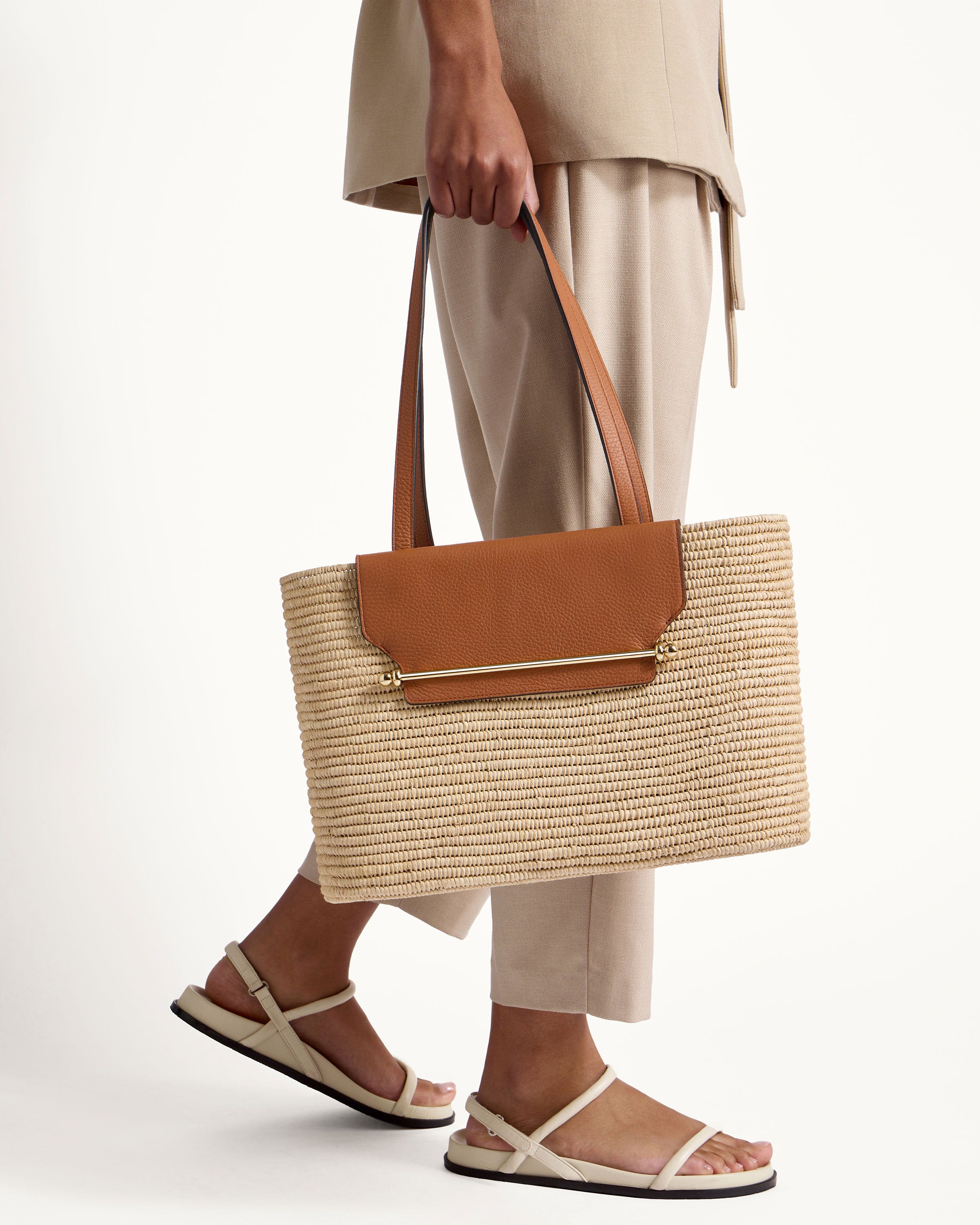 A woman carrying a brown and tan bag