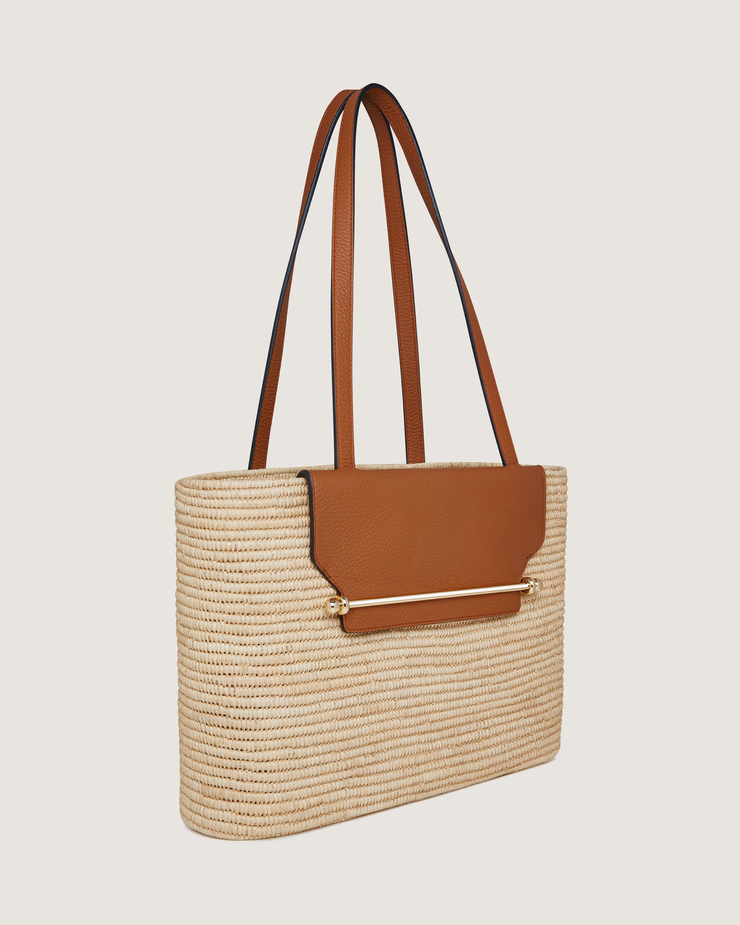 A straw bag with a tan leather handle