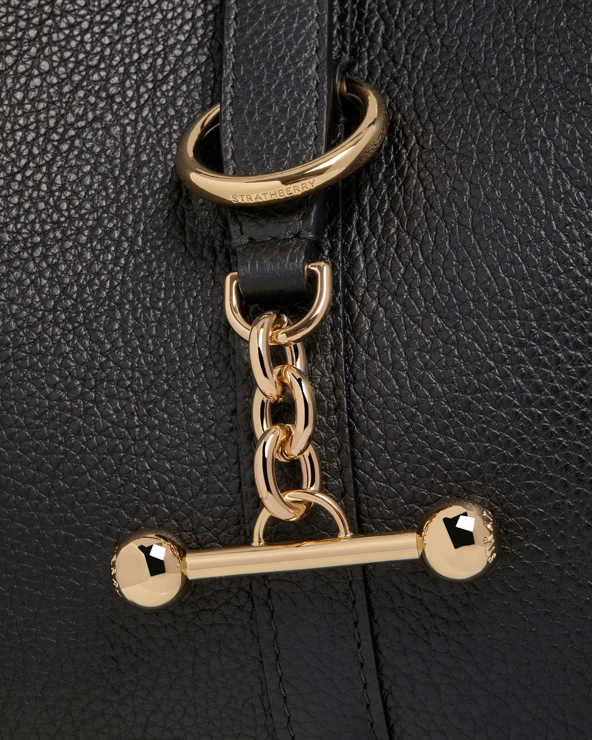 Black pebbled leather bag with Strathberry gold chain and toggle.