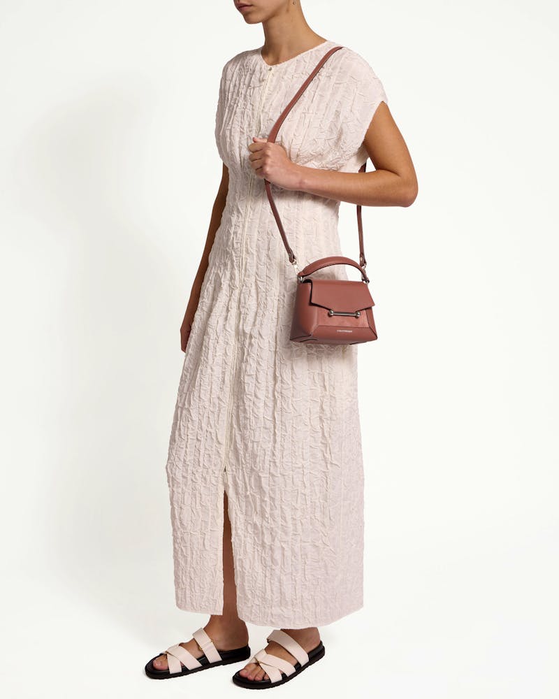 Model wearing a sienna and dusty pink suede Mosaic Nano crossbody bag.