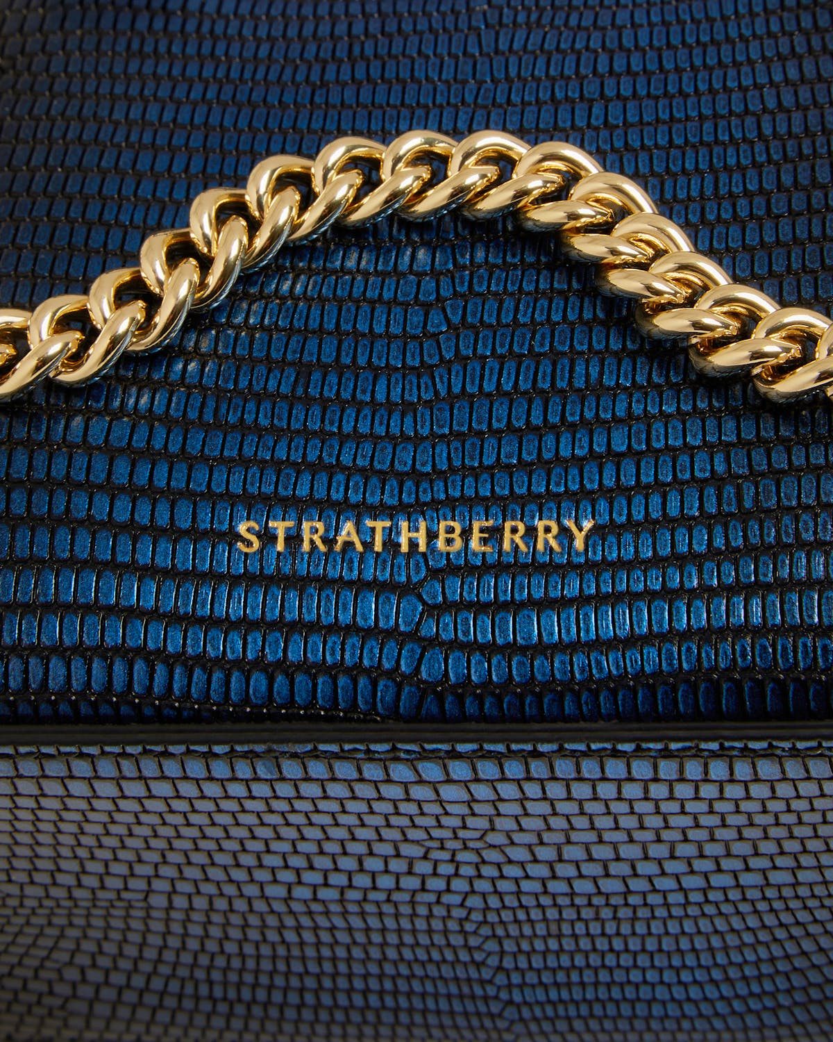 Strathberry nano tote in lizard texture with gold chain strap detail.