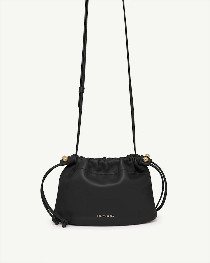 Black Strathberry Charlotte drawstring bag with long shoulder strap and gold hardware