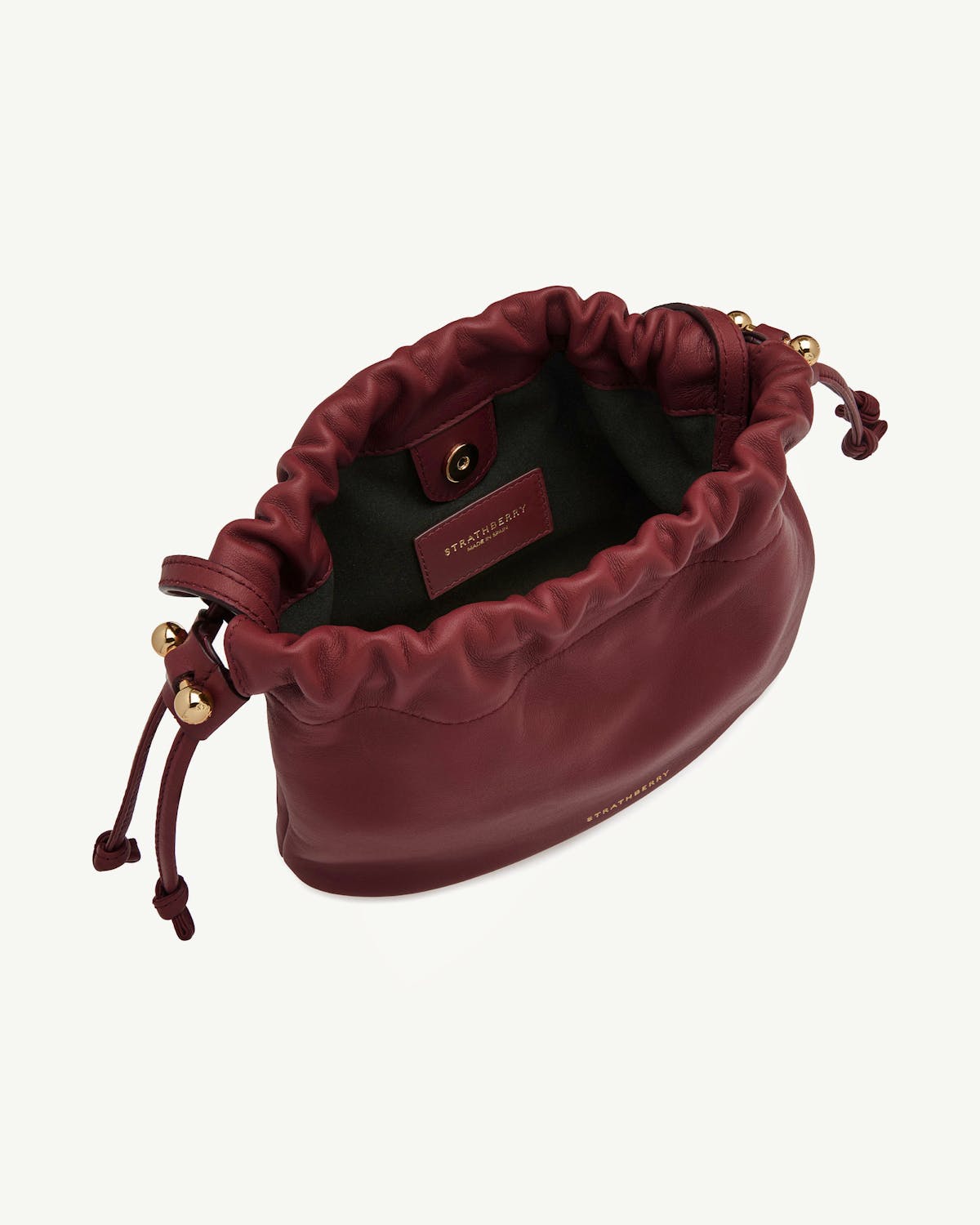 Strathberry Charlotte drawstring bag in oxblood leather with gold hardware