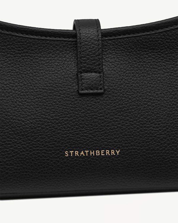 Strathberry black pebbled leather kite on a chain front with gold logo