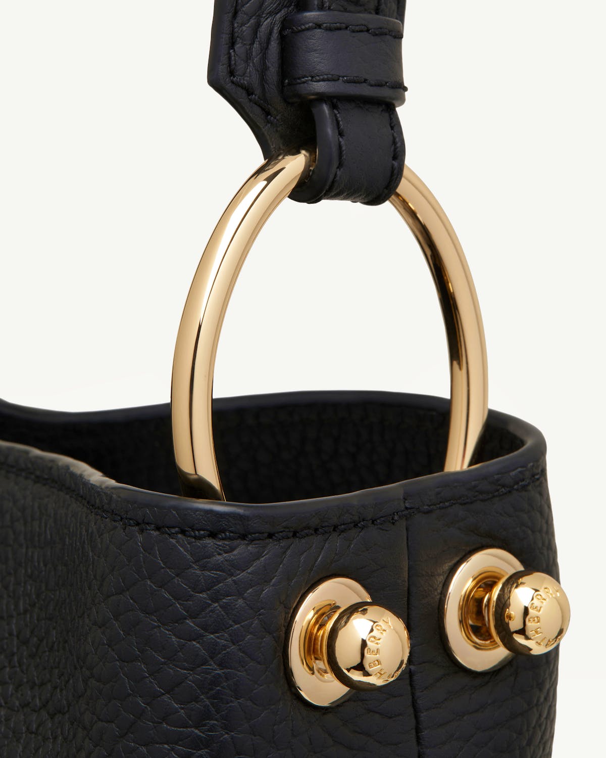 Strathberry Lana Hobo black pebbled leather top corner with gold ring and logo studs.