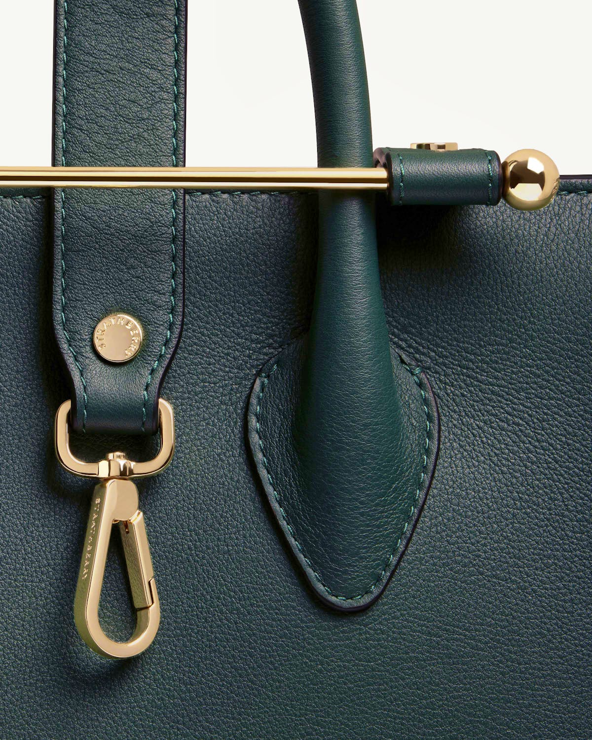 Bottle green Strathberry midi tote front close-up showing handle and gold bar