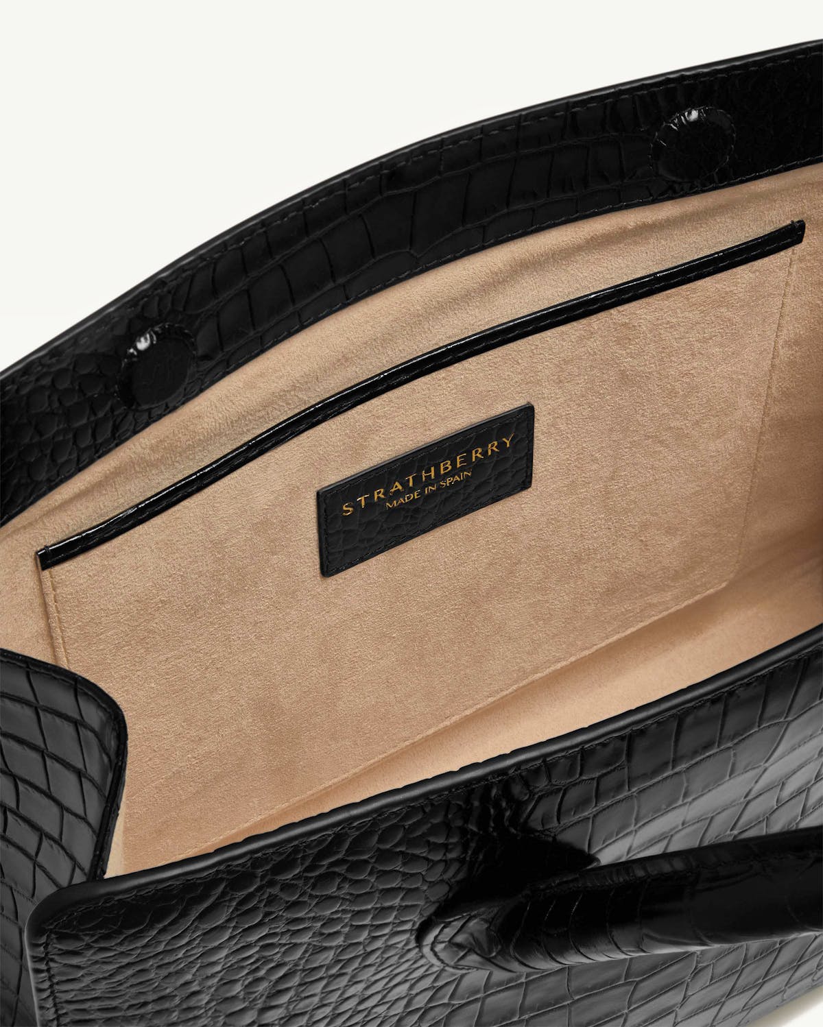 Beige suede interior and pocket of black croc-embossed Strathberry midi tote.