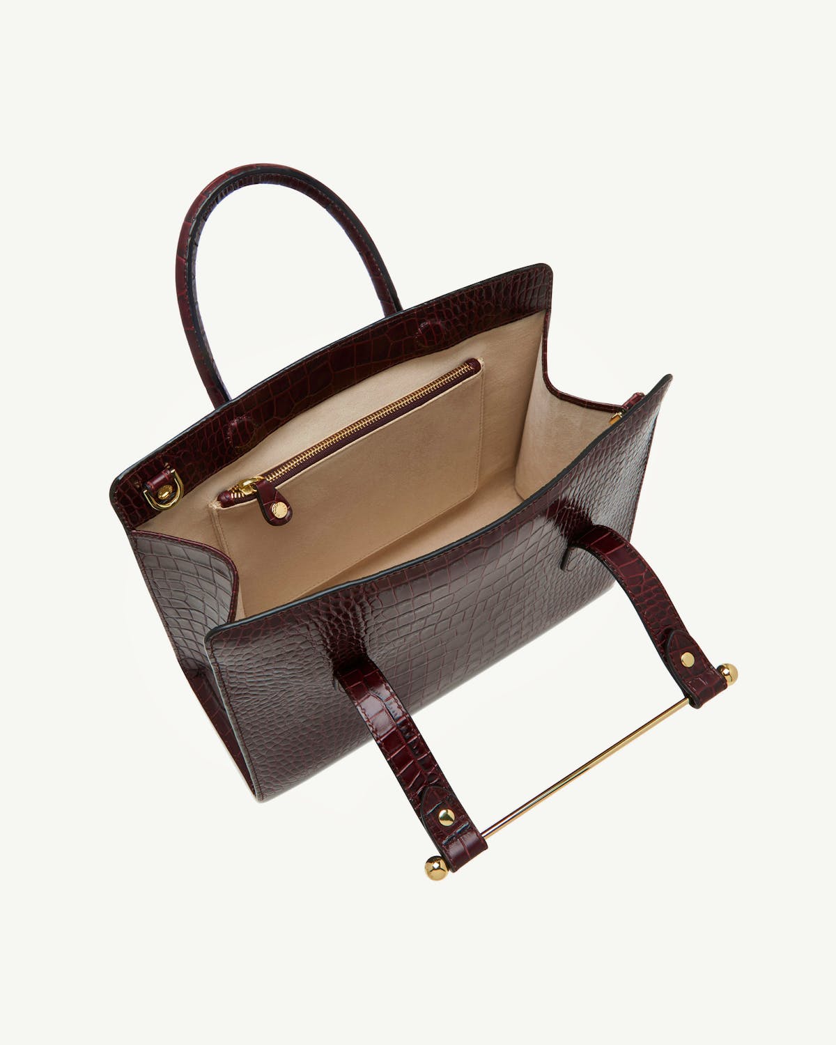 Open croc-embossed midi tote with beige interior, gold zip pocket and gold bar handle.