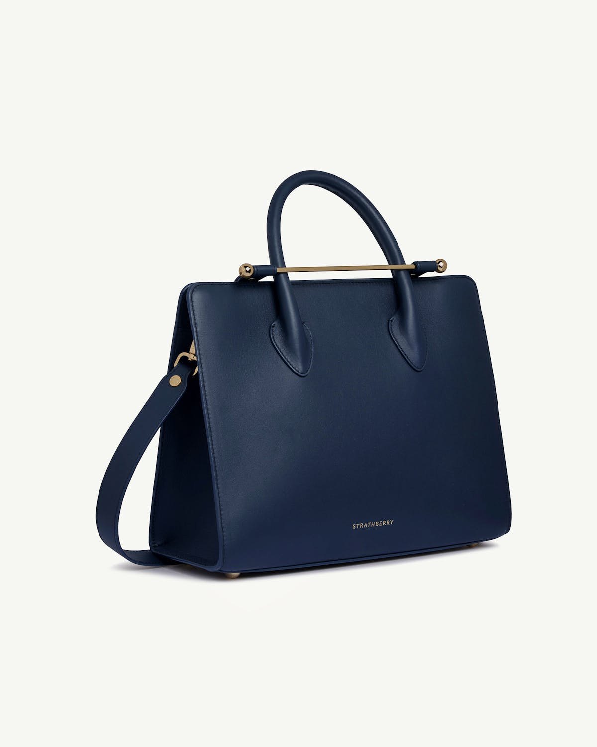 Strathberry midi tote in marine blue, angled front view with shoulder strap
