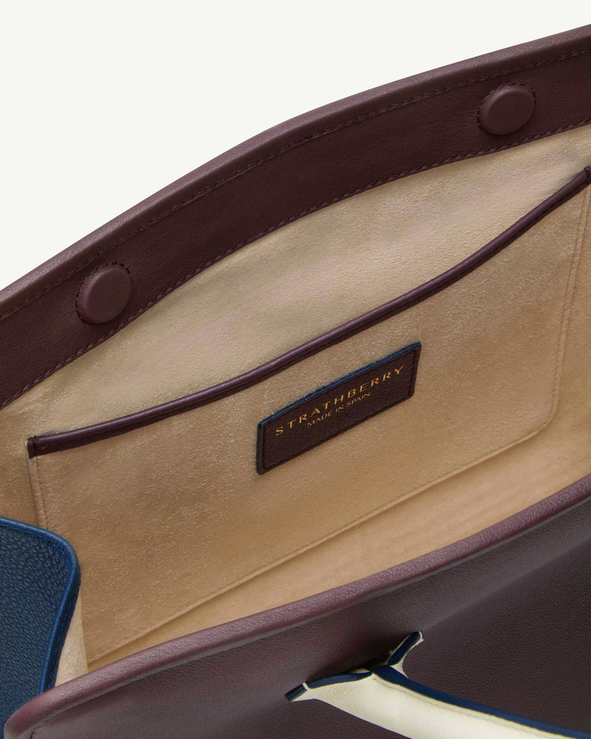Strathberry midi tote interior with suede lining, pocket and burgundy trim.