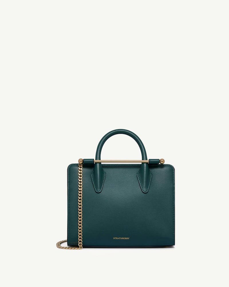 Strathberry bottle-green mini tote with gold bar handle and chain strap.