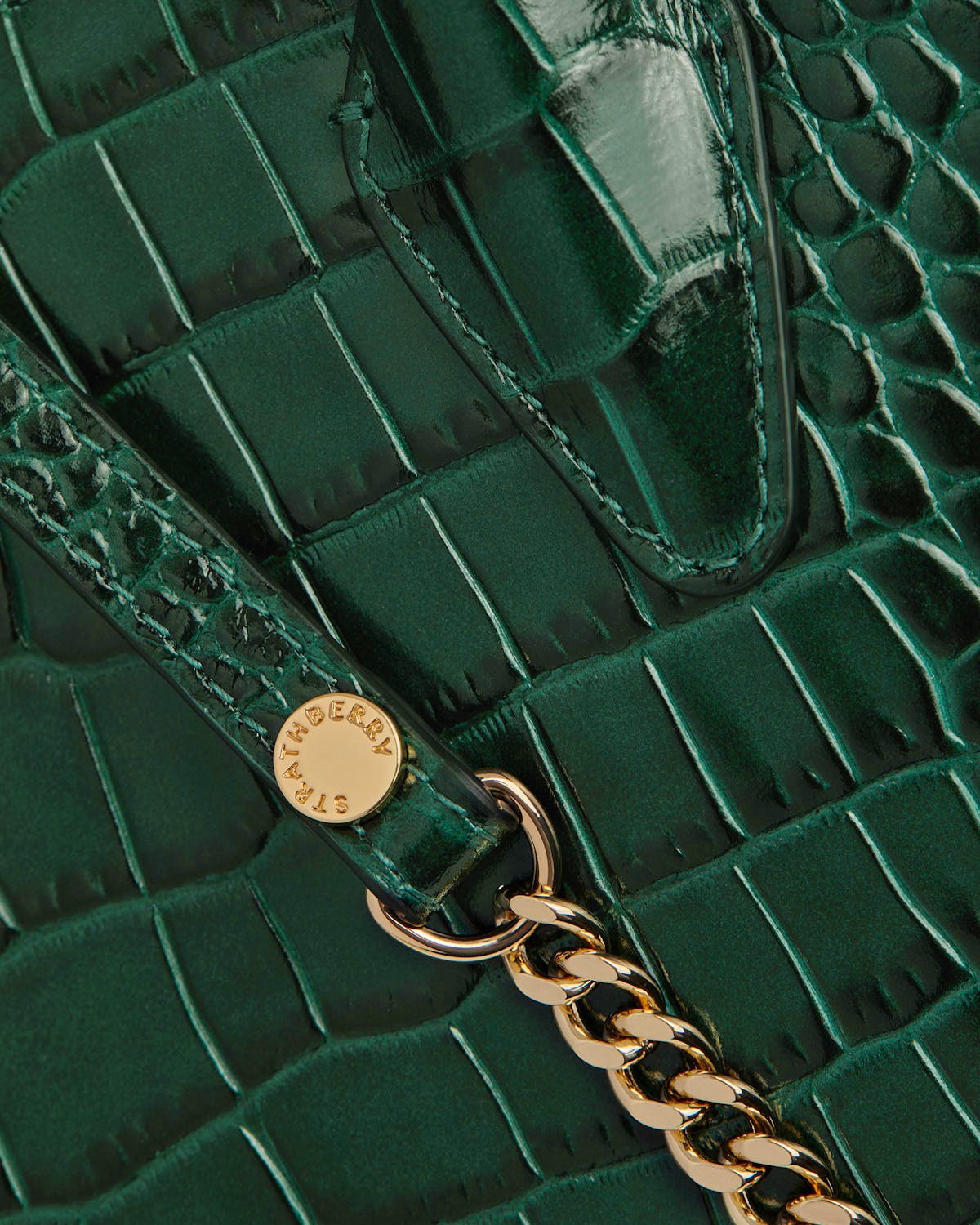 Strathberry green croc mini tote close-up showing strap, gold chain and hardware