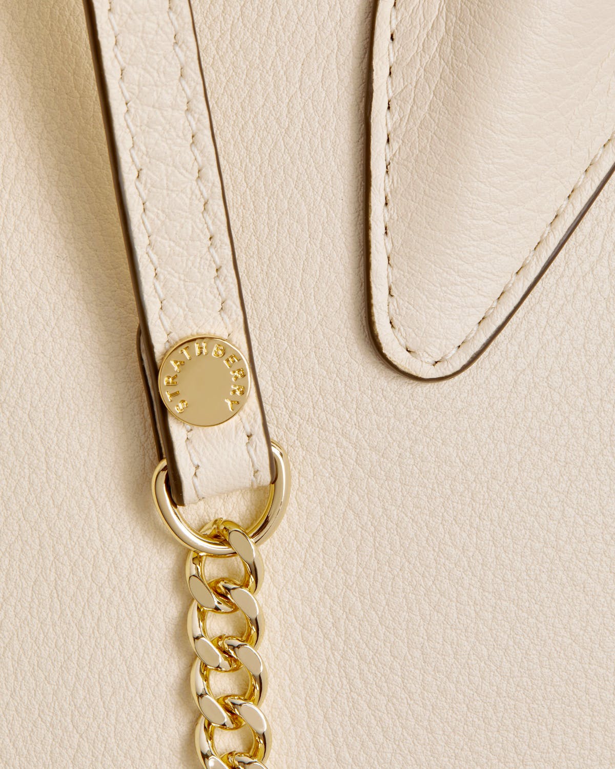 Vanilla mini tote front strap with gold chain and Strathberry logo.