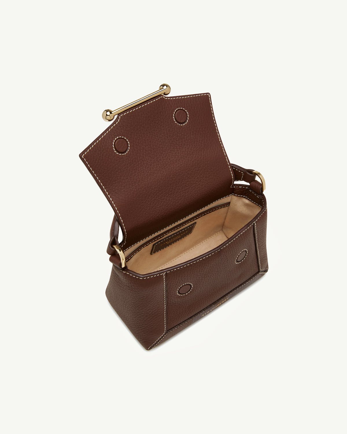 Chocolate leather mini bag with open flap, vanilla interior and contrast stitching.