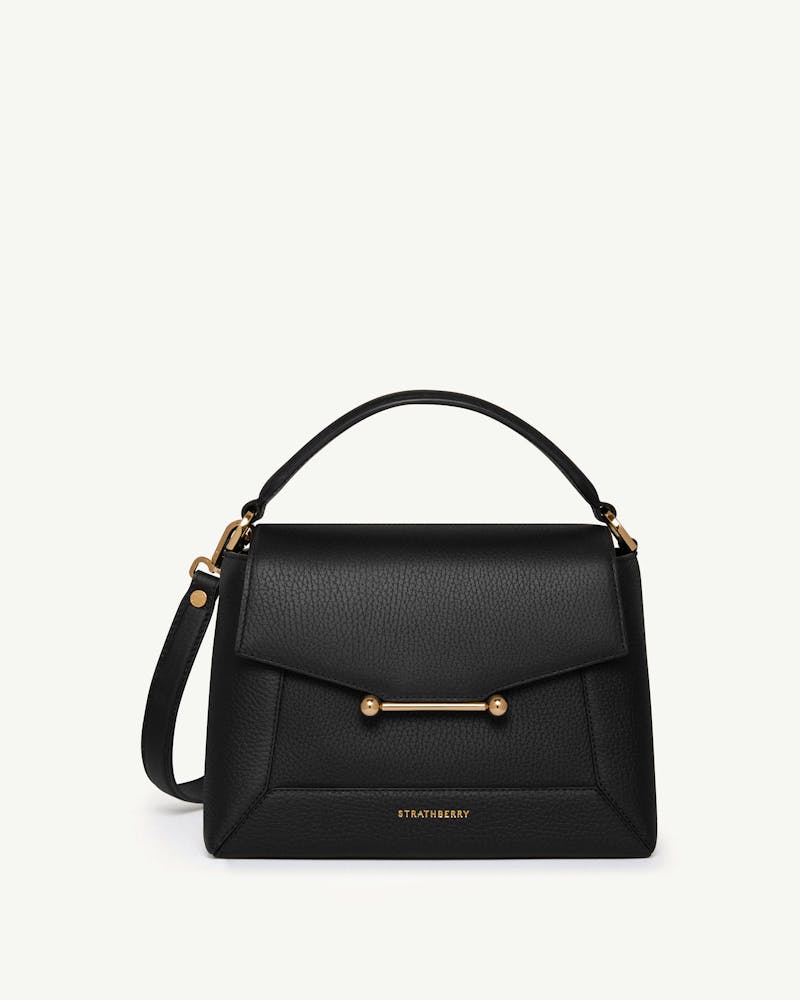 Strathberry black mosaic bag with top handle and gold bar hardware.