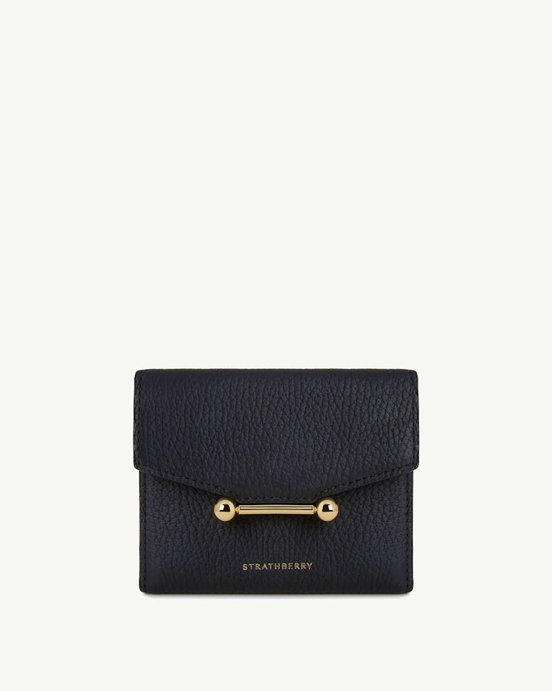 Black textured trifold wallet with gold bar fastening and Strathberry logo.