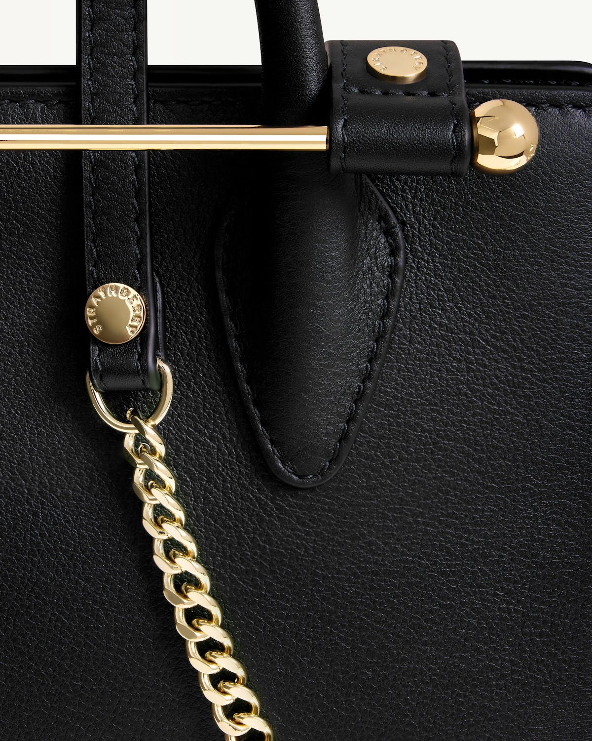 Strathberry nano tote black leather close-up of gold bar and chain