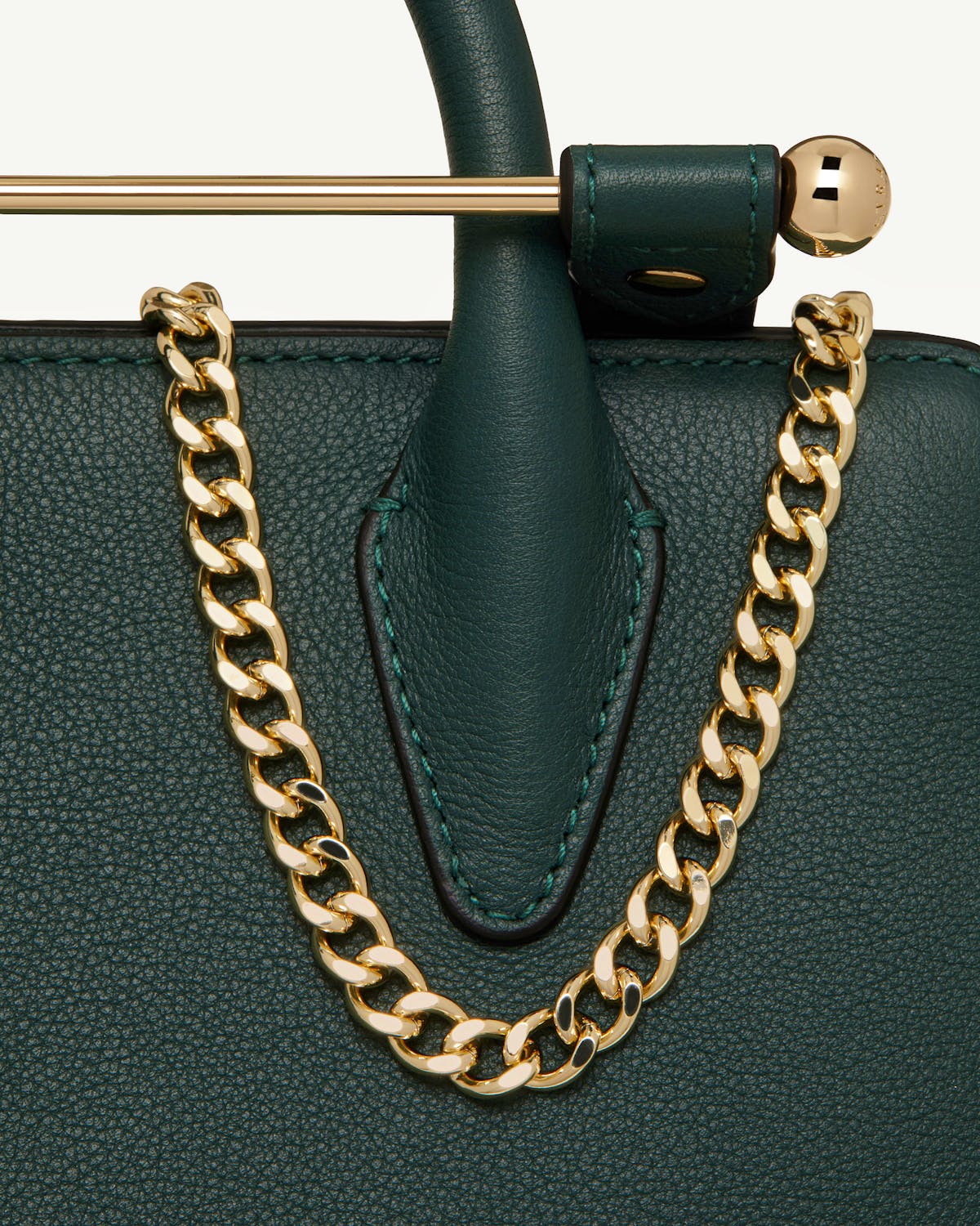 Bottle green nano tote close-up of textured leather, top handle and gold chain.