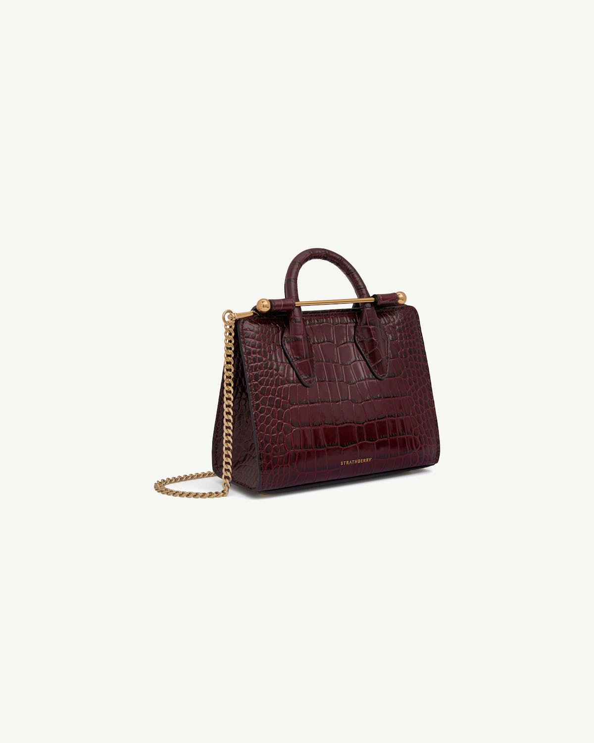 Burgundy croc-embossed nano tote with top handle, gold bar, chain strap, Strathberry.
