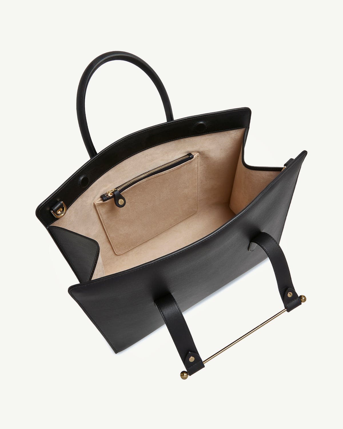 Black leather tote open to show beige suede interior, zip pocket and gold bar.