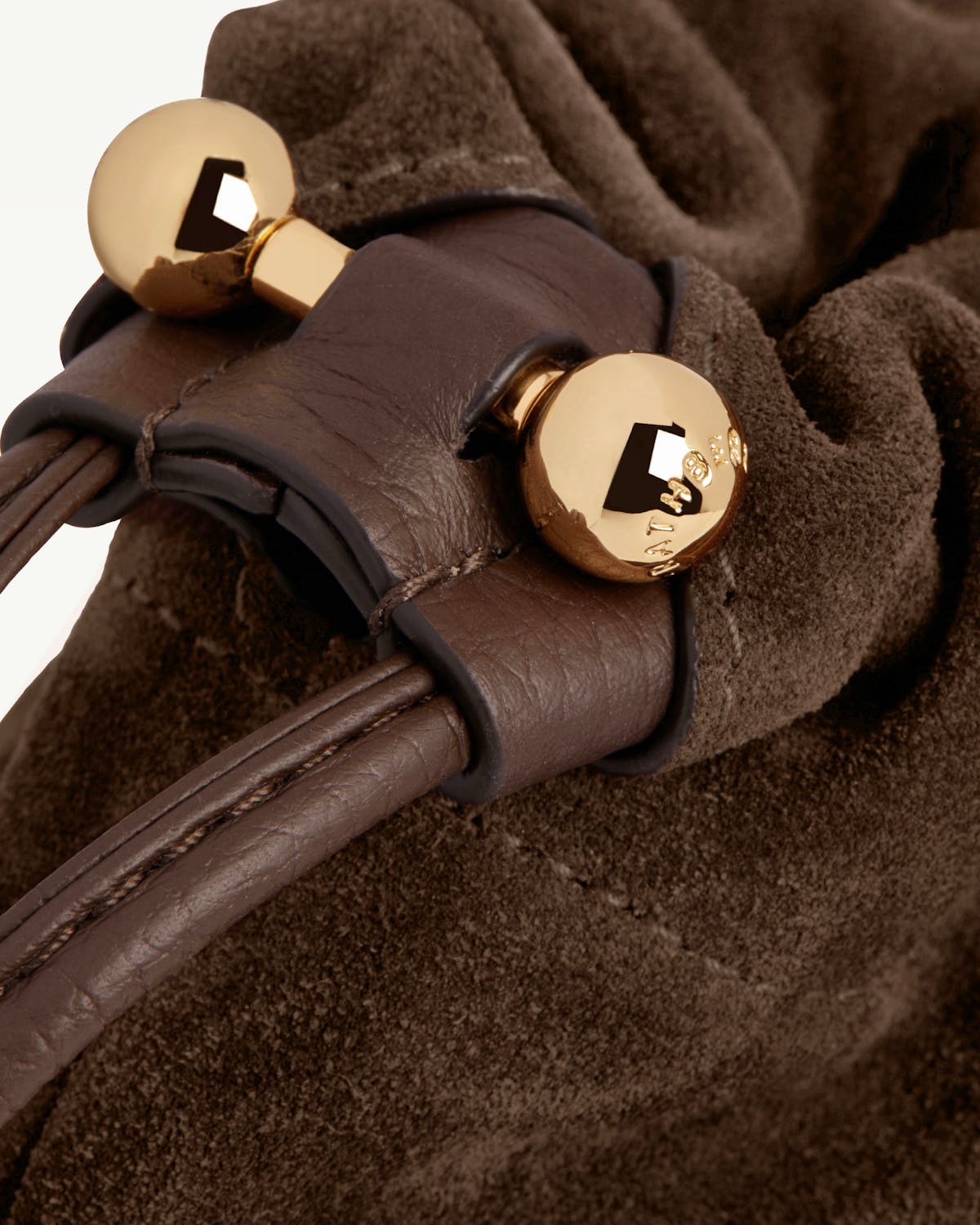 Chocolate suede drawstring bag with leather cord and gold ball toggle hardware.