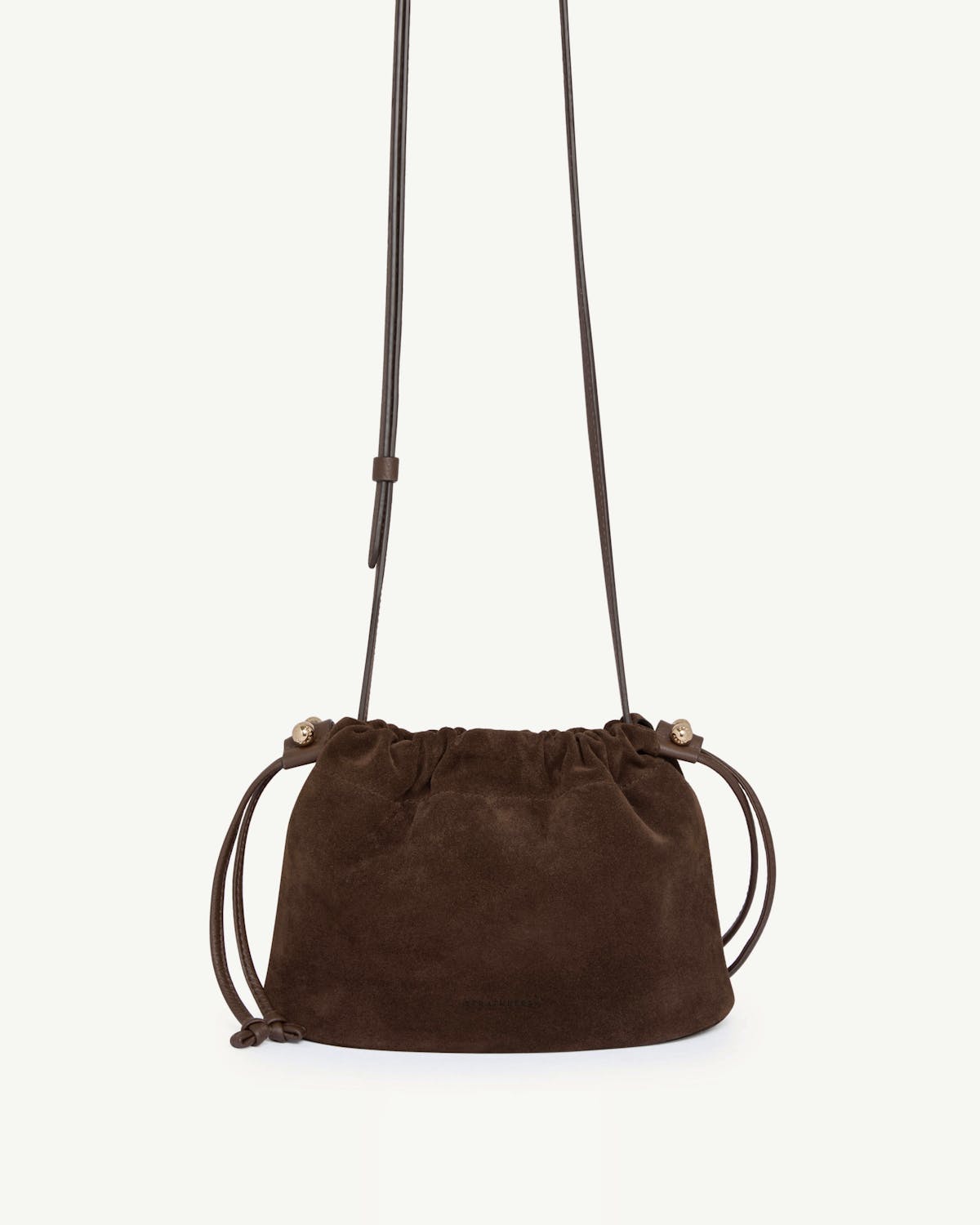 Chocolate suede drawstring bag with a long leather strap and gathered top.