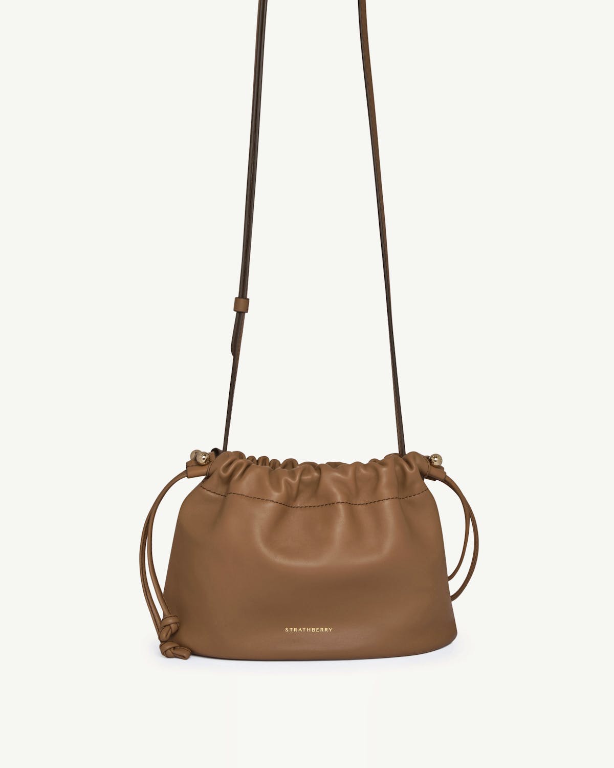 Strathberry Charlotte drawstring leather bag in clay with long shoulder strap.