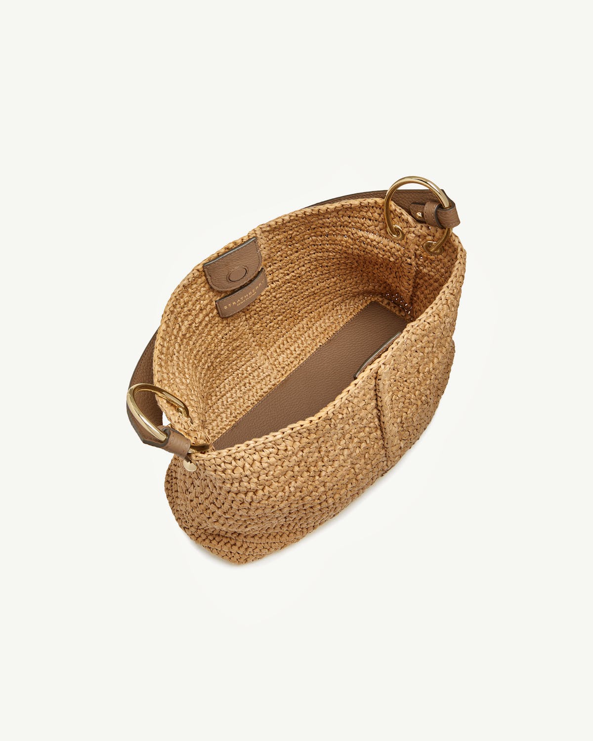 Raffia hobo bag with clay leather trim and gold ring hardware, open top.